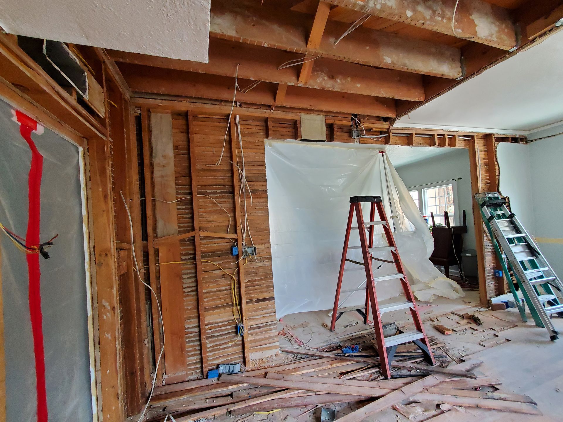 A ladder is sitting in the middle of a room under construction.