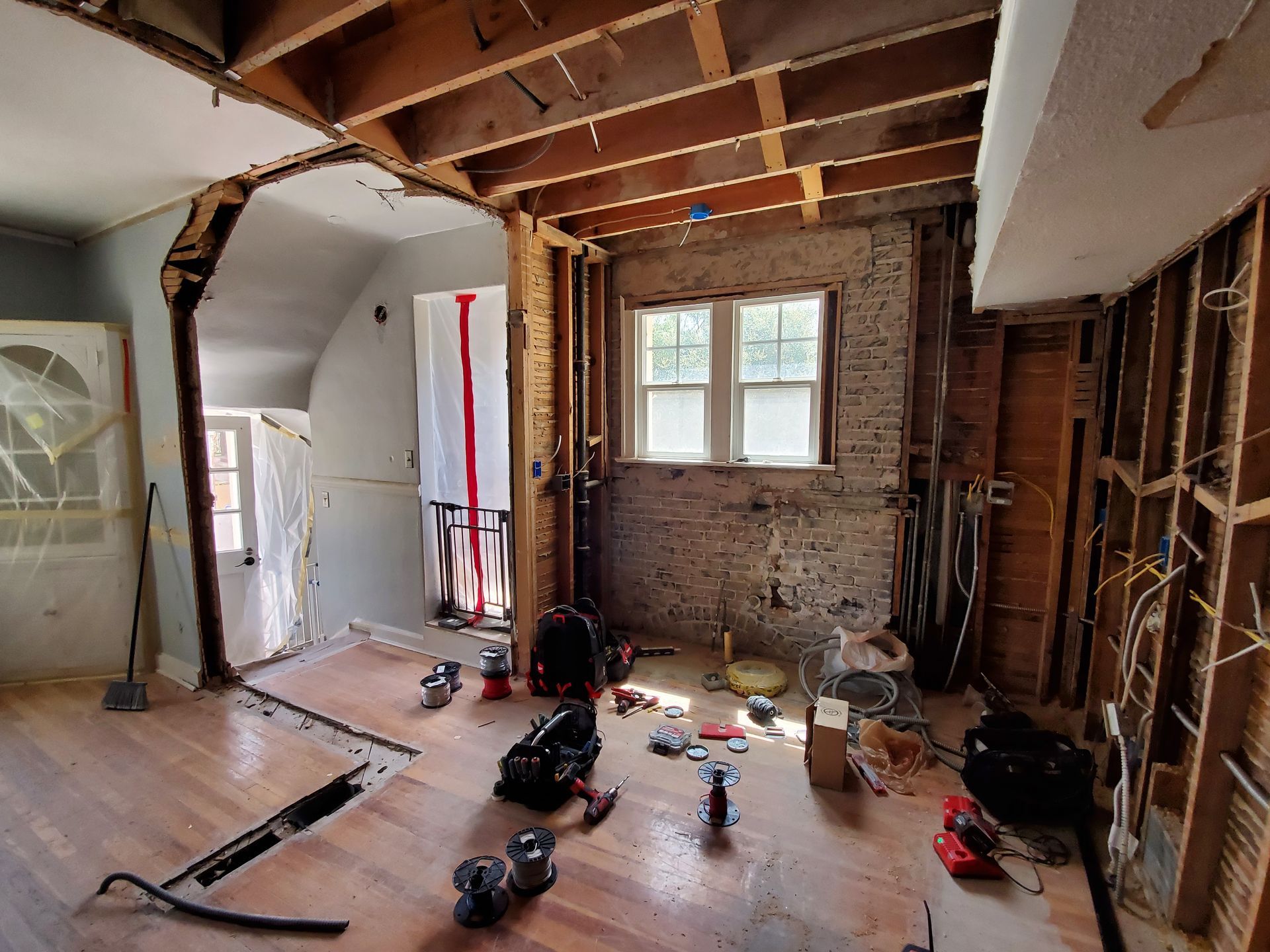 A room with a lot of tools on the floor and a brick wall.