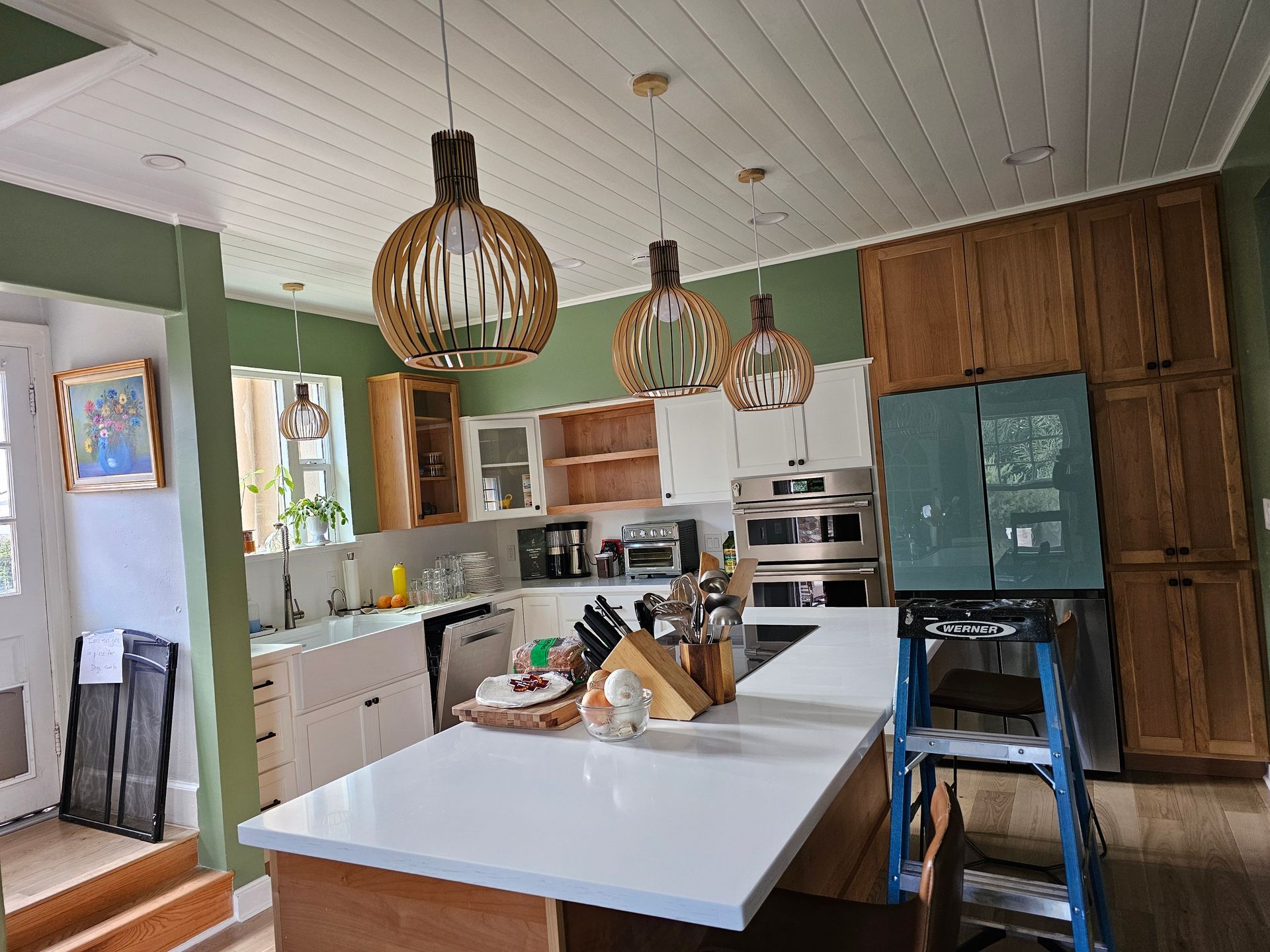 A kitchen with a large island and a ladder.
