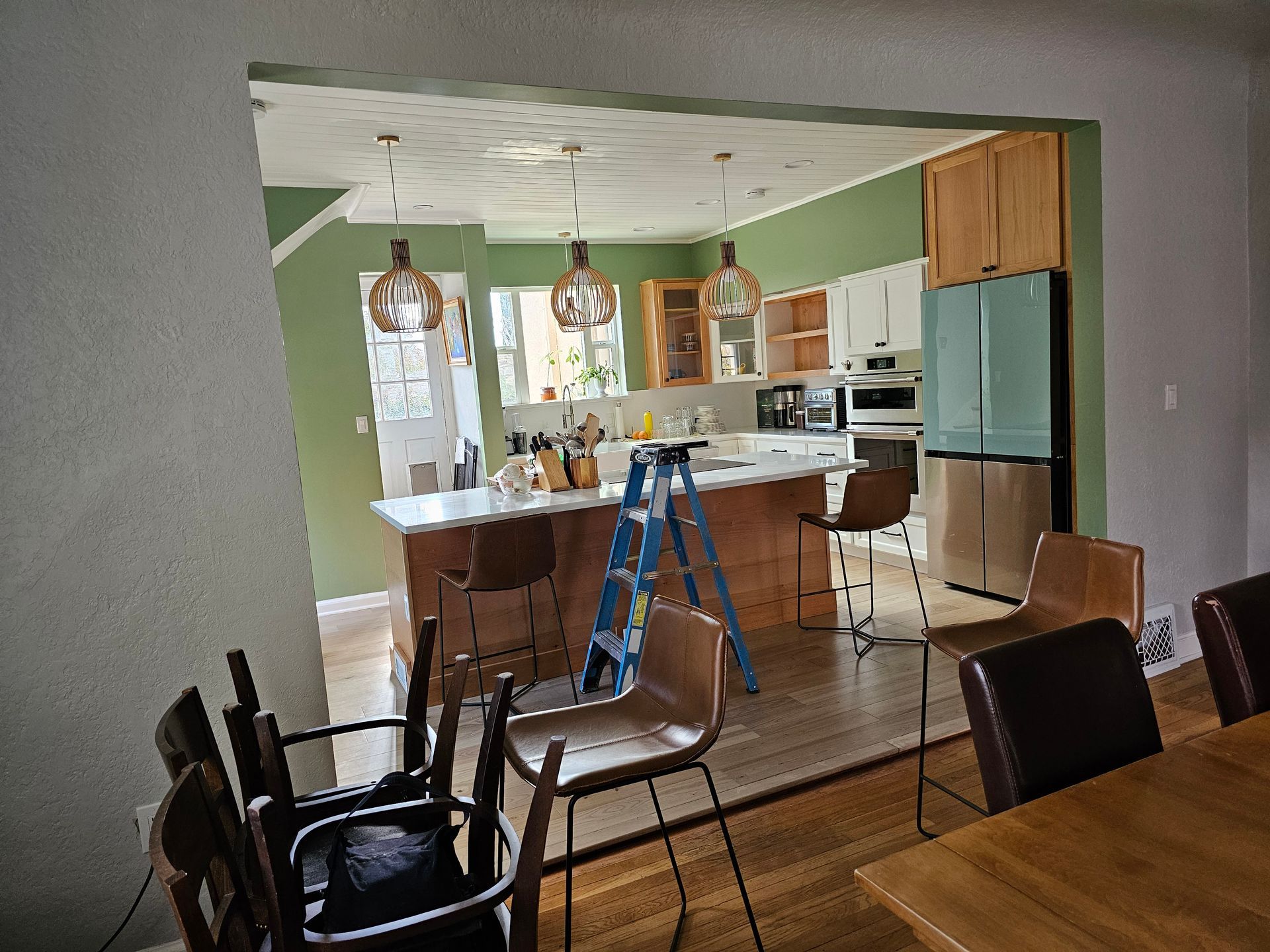 A kitchen with a blue ladder in the middle of it.