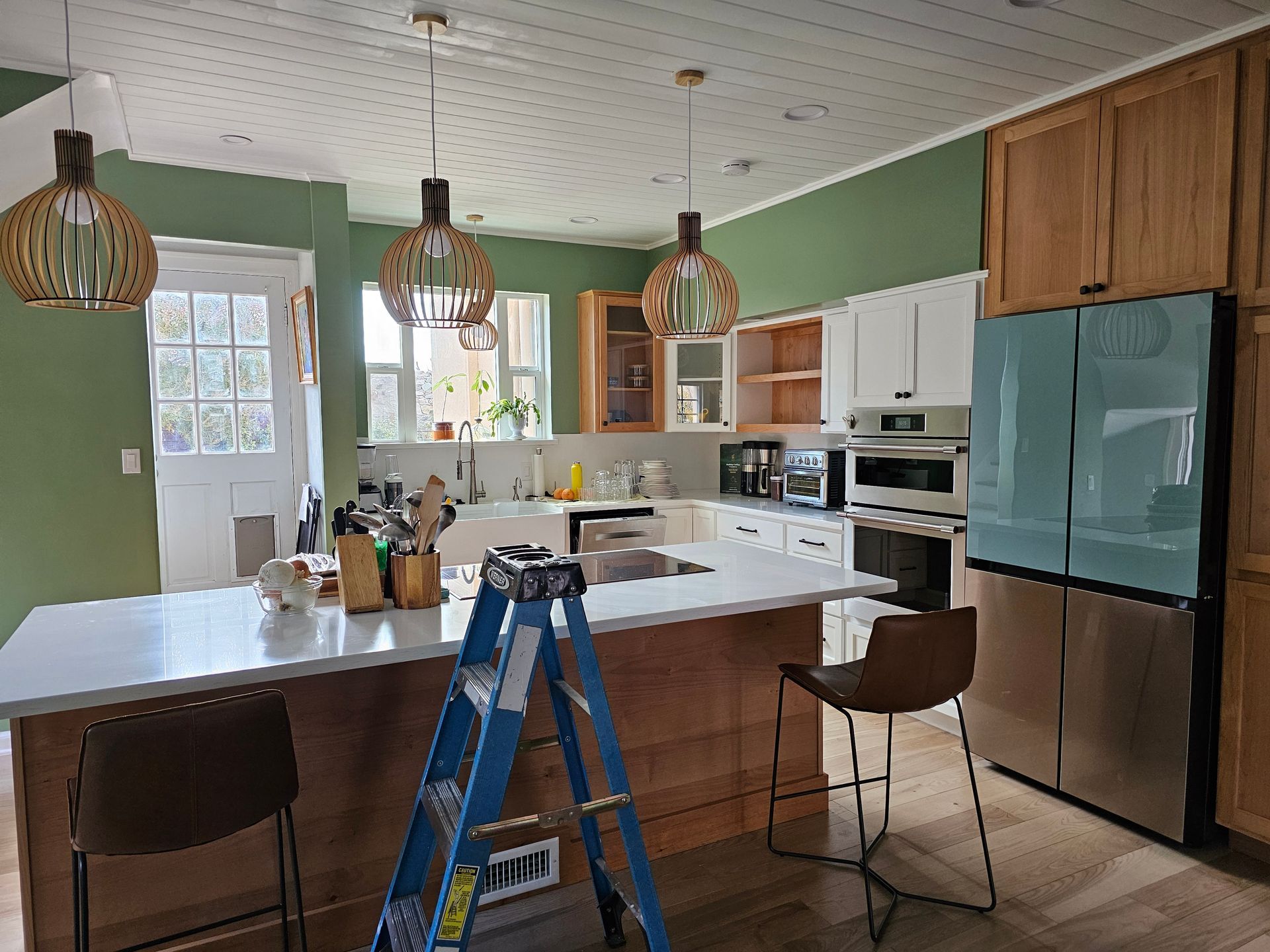 A kitchen with a blue ladder sitting on the counter.