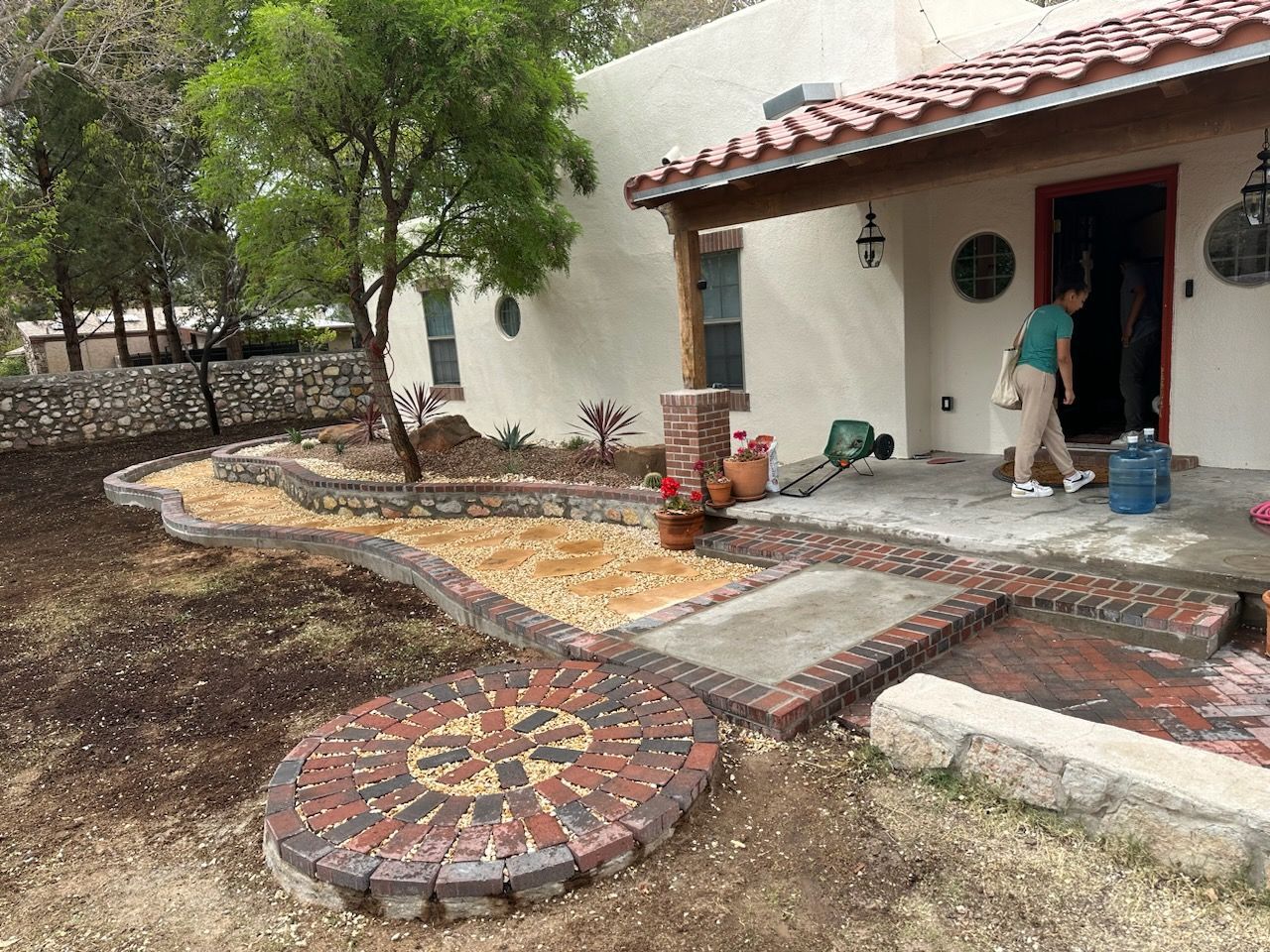 A man is standing on a porch in front of a house.