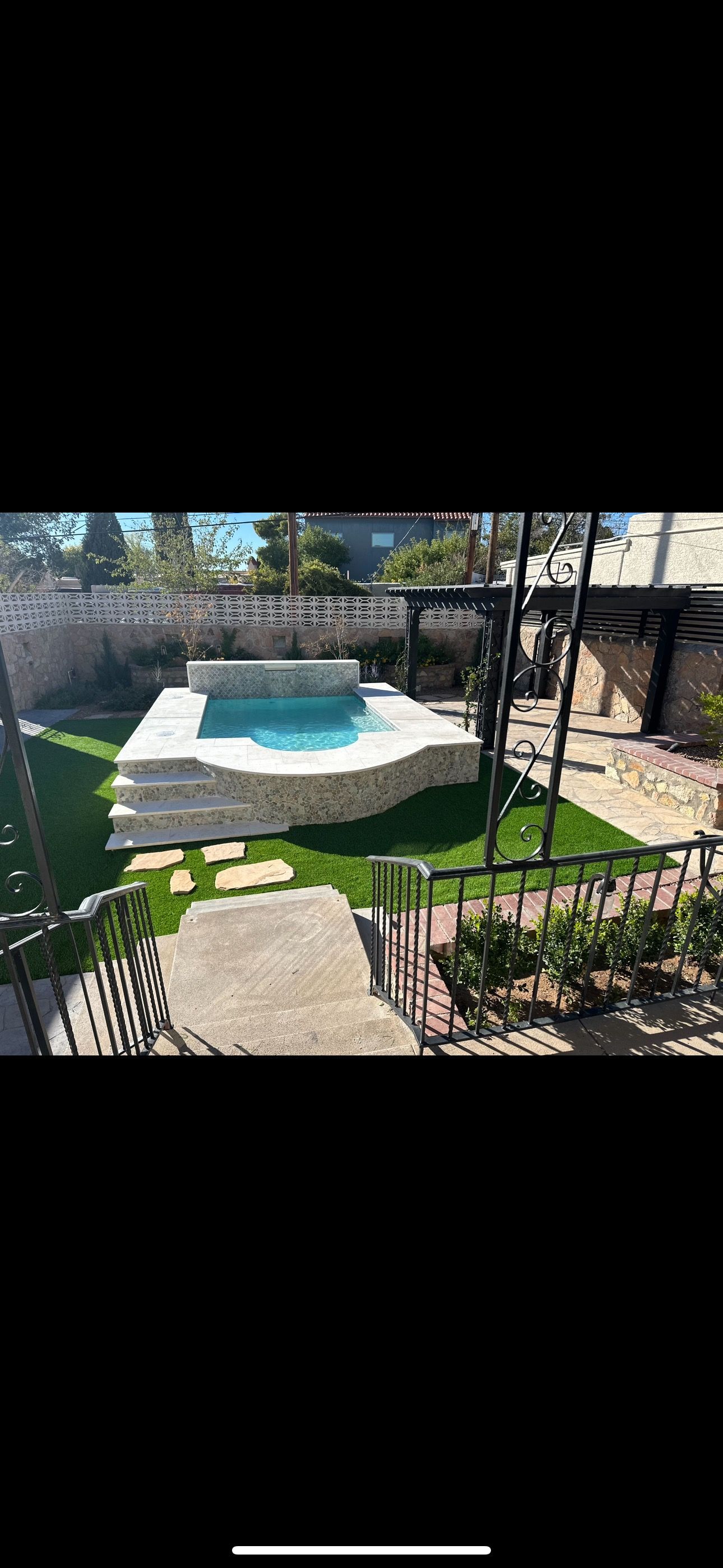 There is a swimming pool in the middle of the backyard.