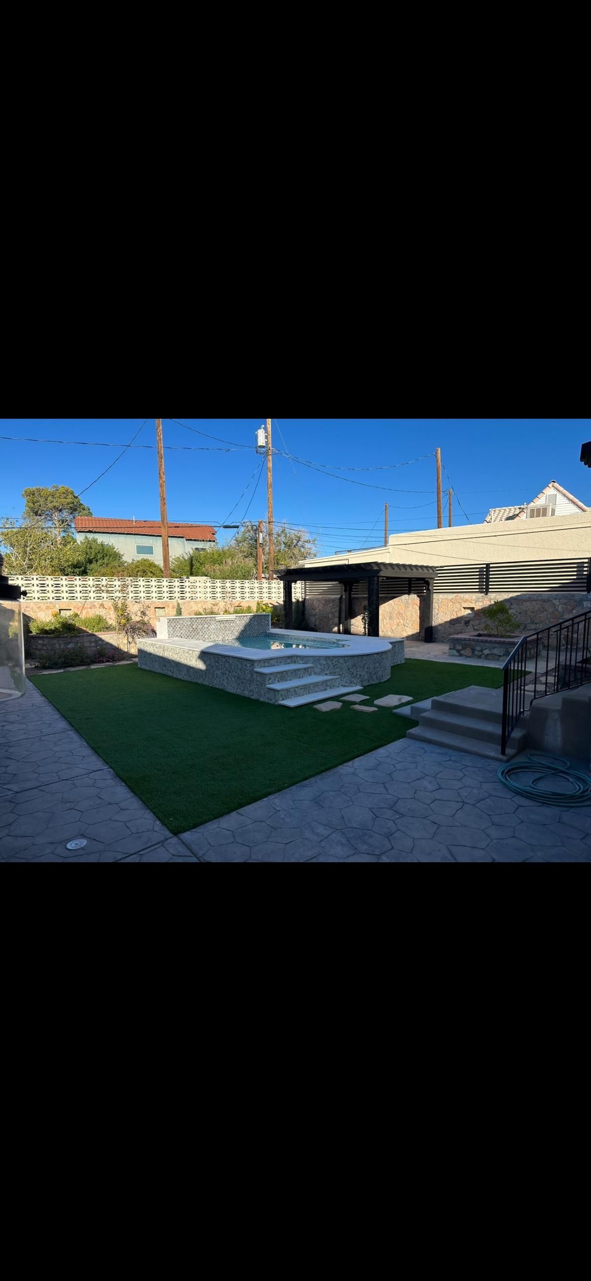 A large swimming pool is sitting on top of a lush green lawn in a backyard.