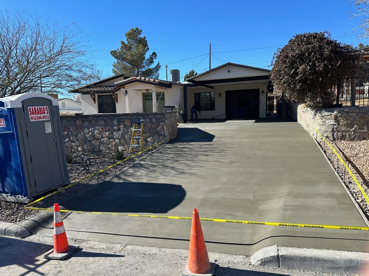 A concrete driveway is being built in front of a house.