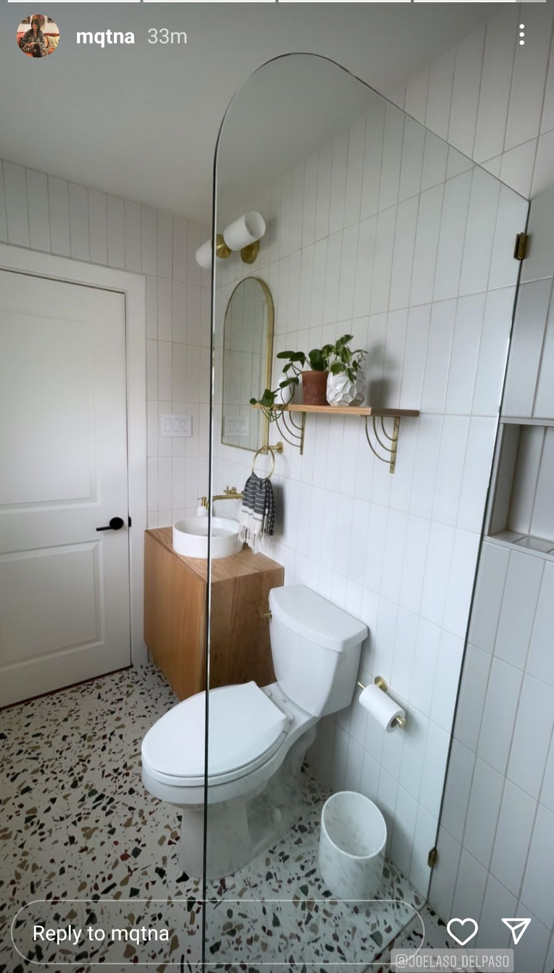A bathroom with a toilet , sink and mirror.