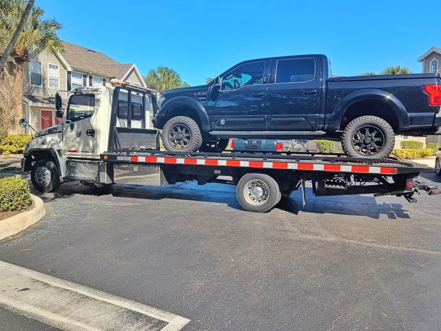 Flatbed tow truck transporting a vehicle in Naples FL