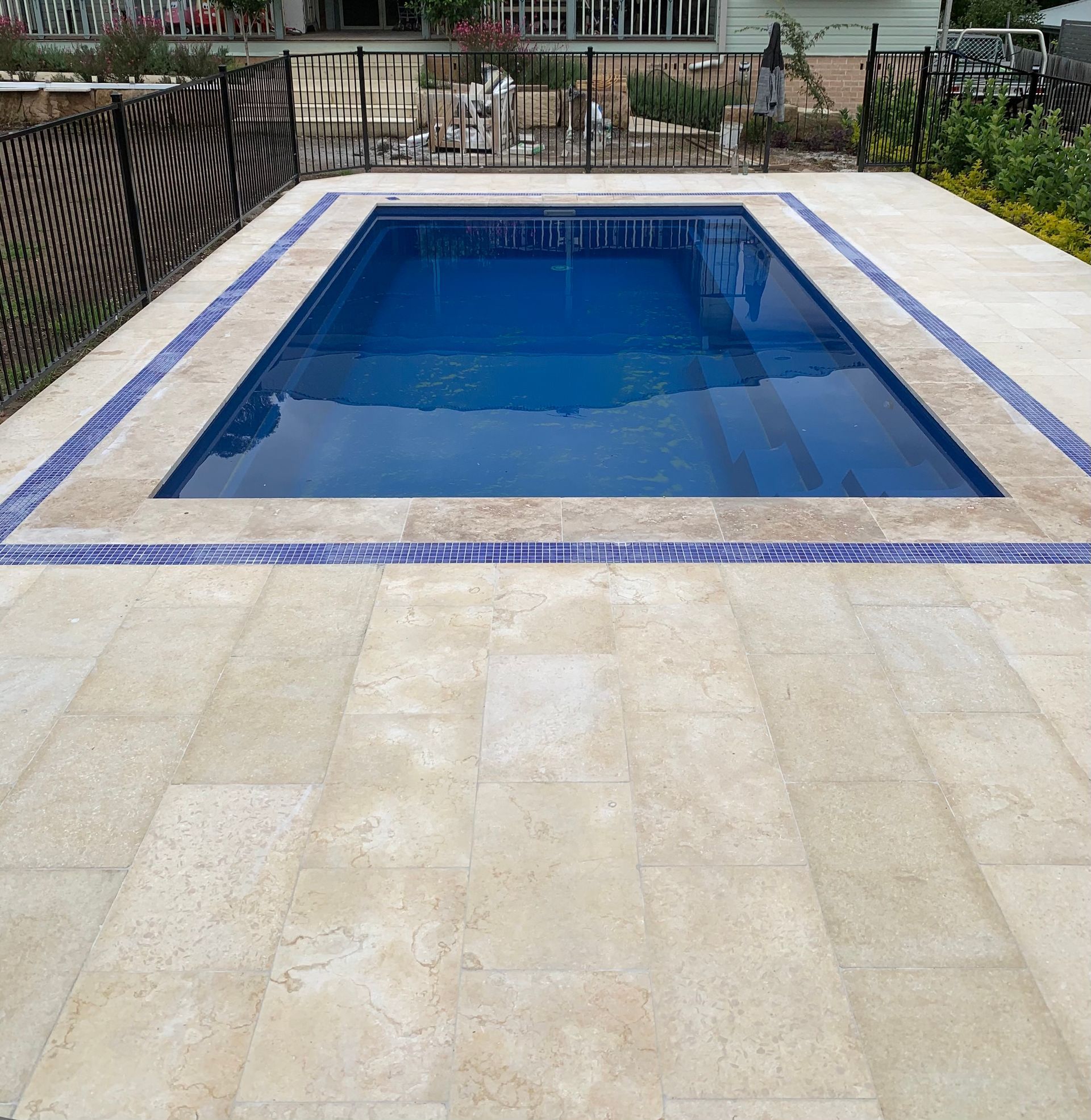 A large swimming pool with a fence around it