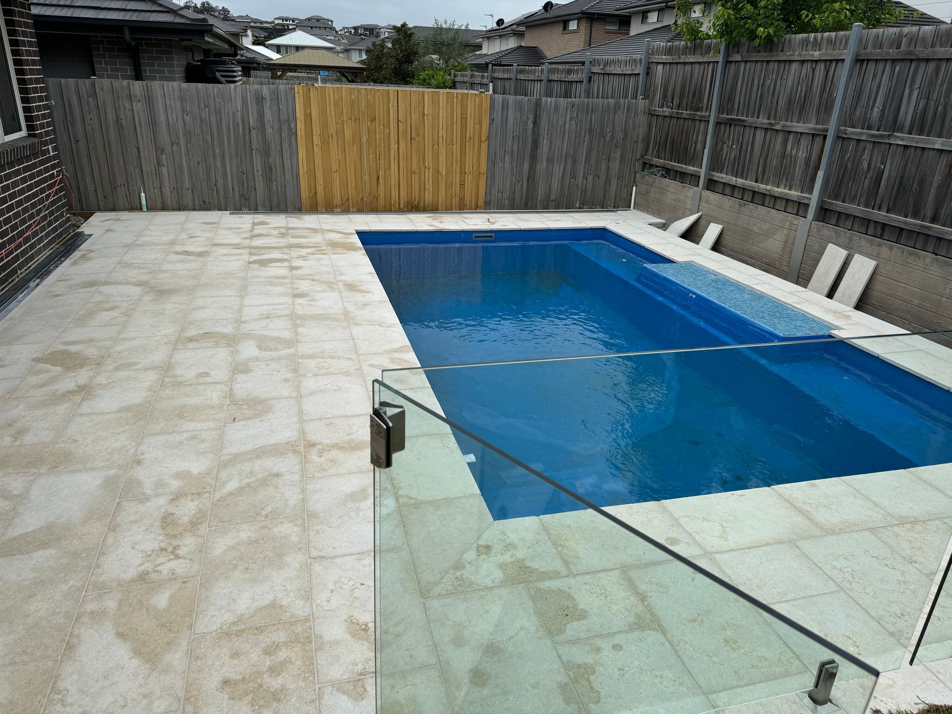 The front door of a brick house with a hose in front of it.
