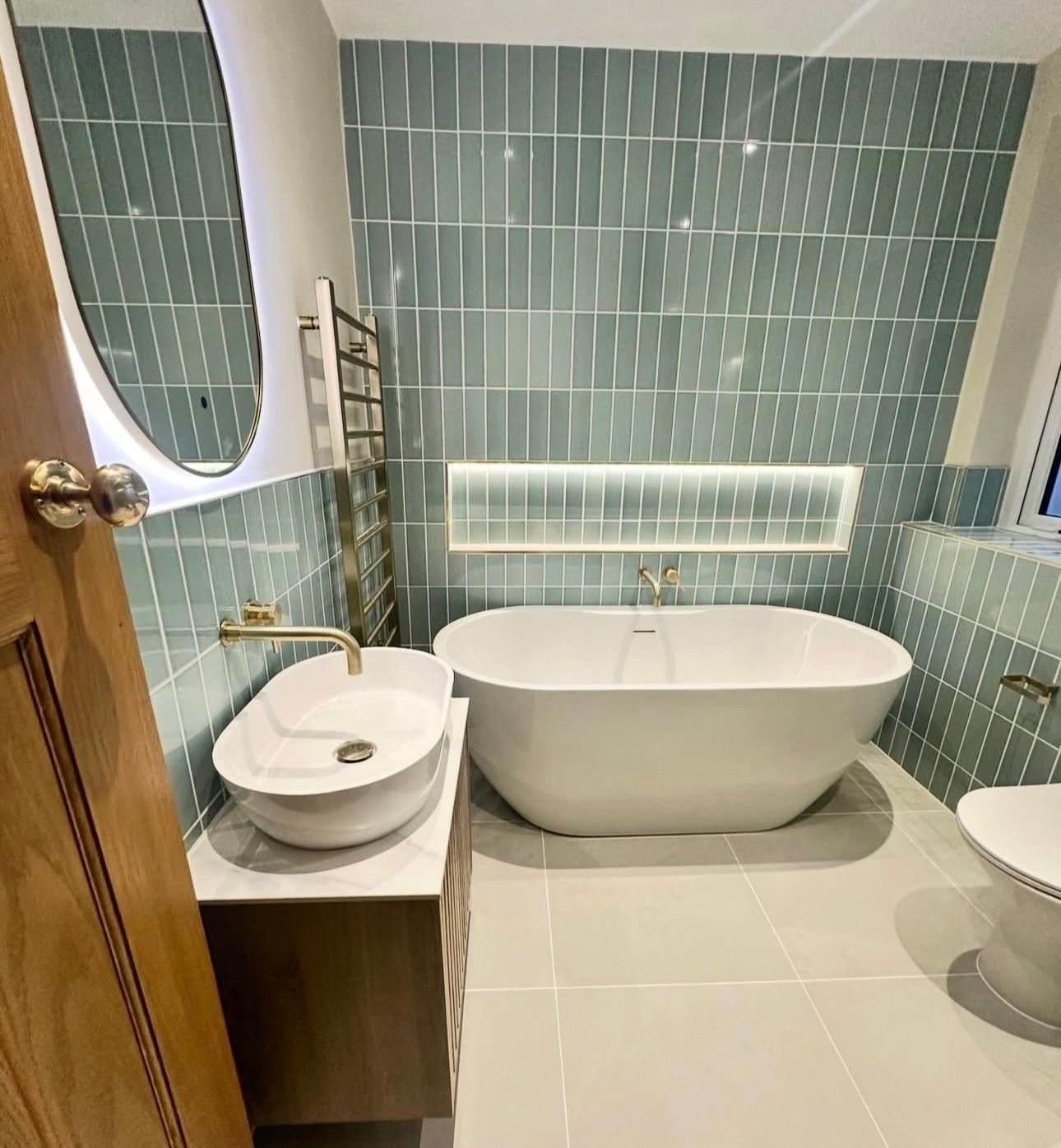 A bathroom with a bathtub , sink , toilet and mirror.