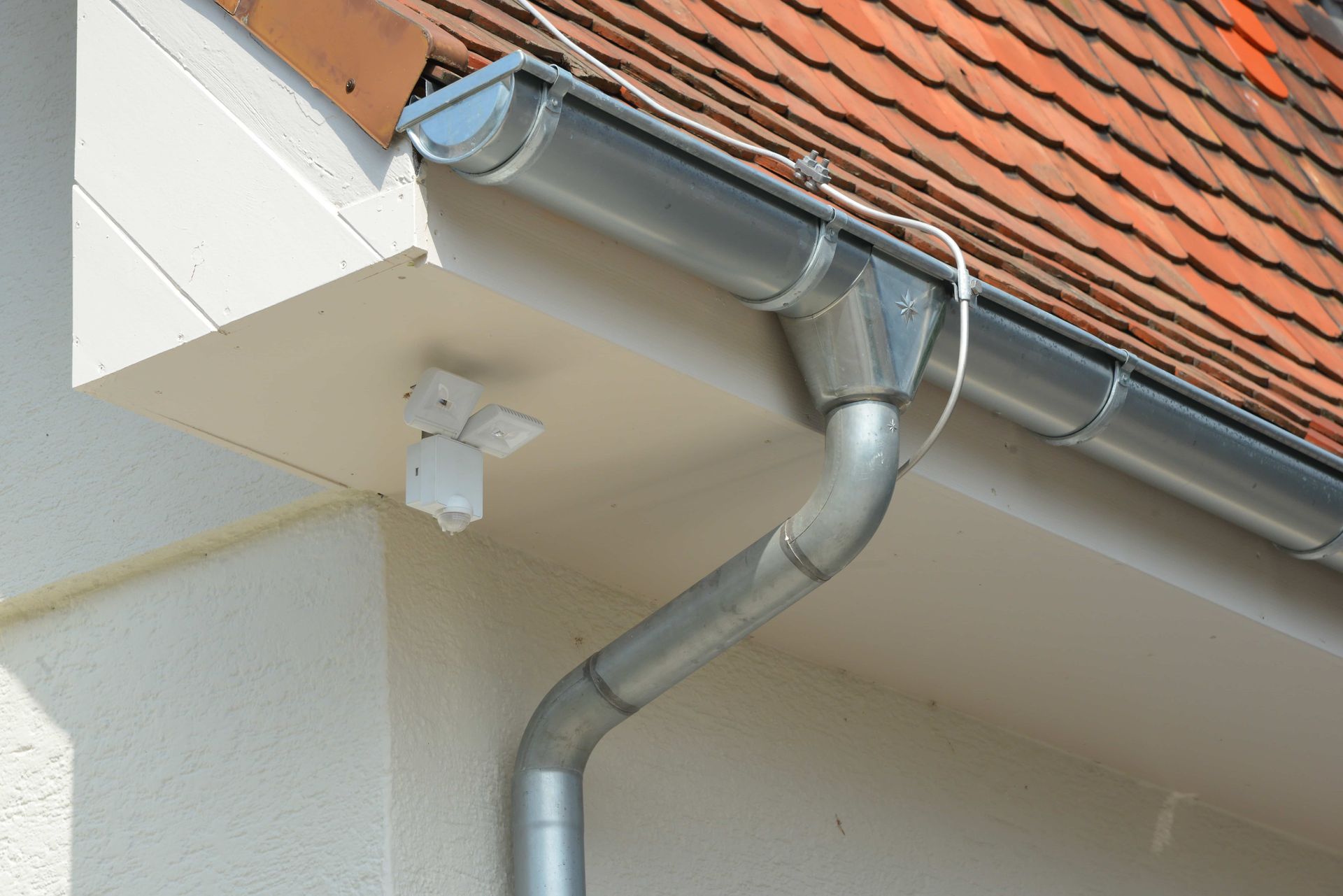 A close up of a gutter on the side of a building.