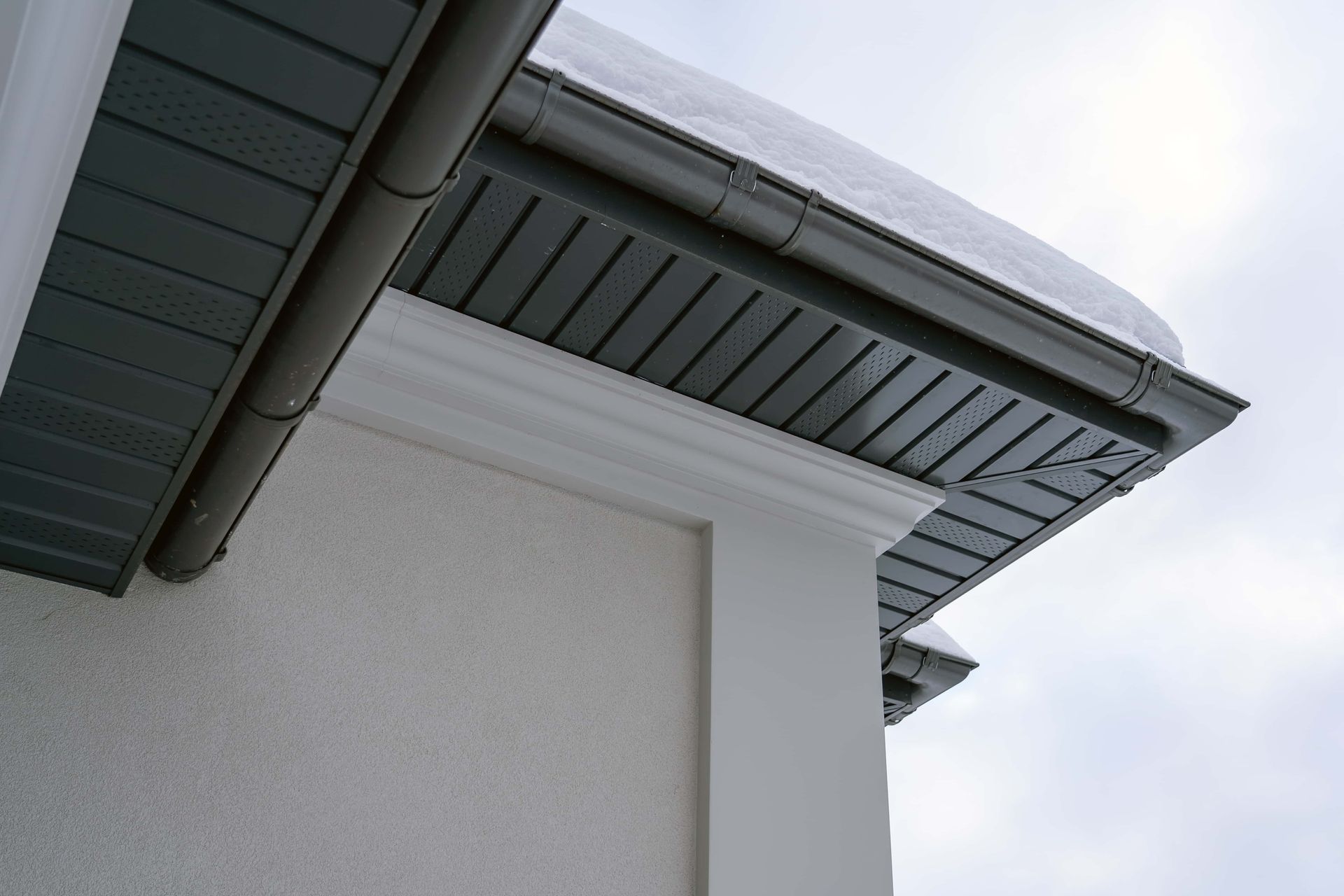 A close up of the roof of a house with snow on it.