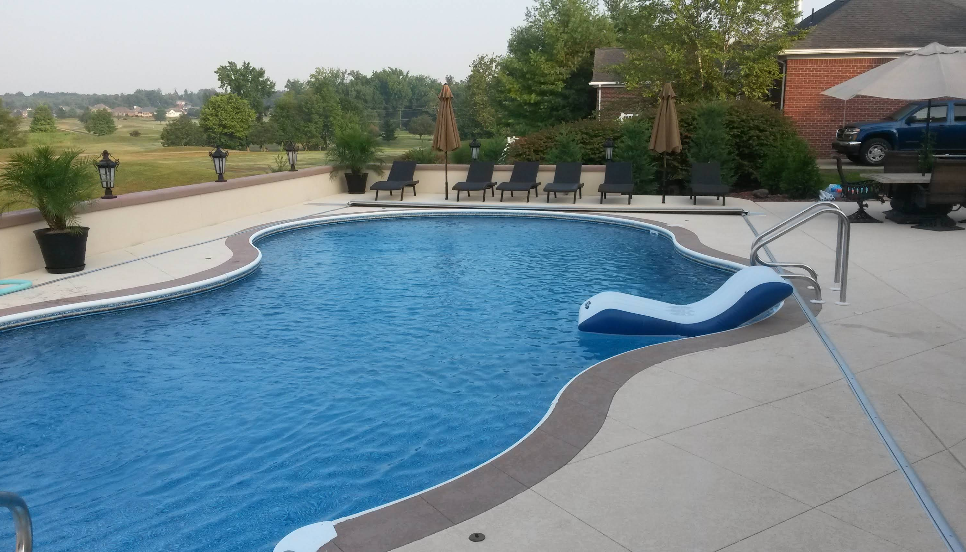 A large swimming pool with chairs and umbrellas around it