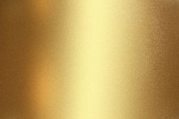 Uno sfondo color oro metallizzato con una sottile sfumatura di luce verticale e una finitura a grana fine e texturizzata.