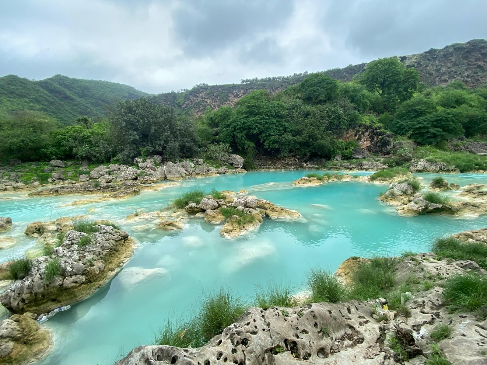 Khareef in Dhofar Oman - turquoise water pools and lush green vegetation