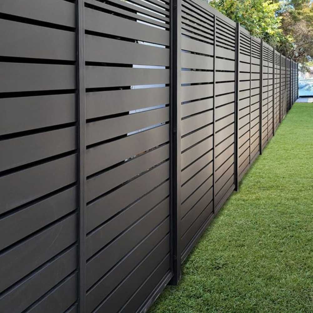 A black fence is sitting on top of a lush green lawn.