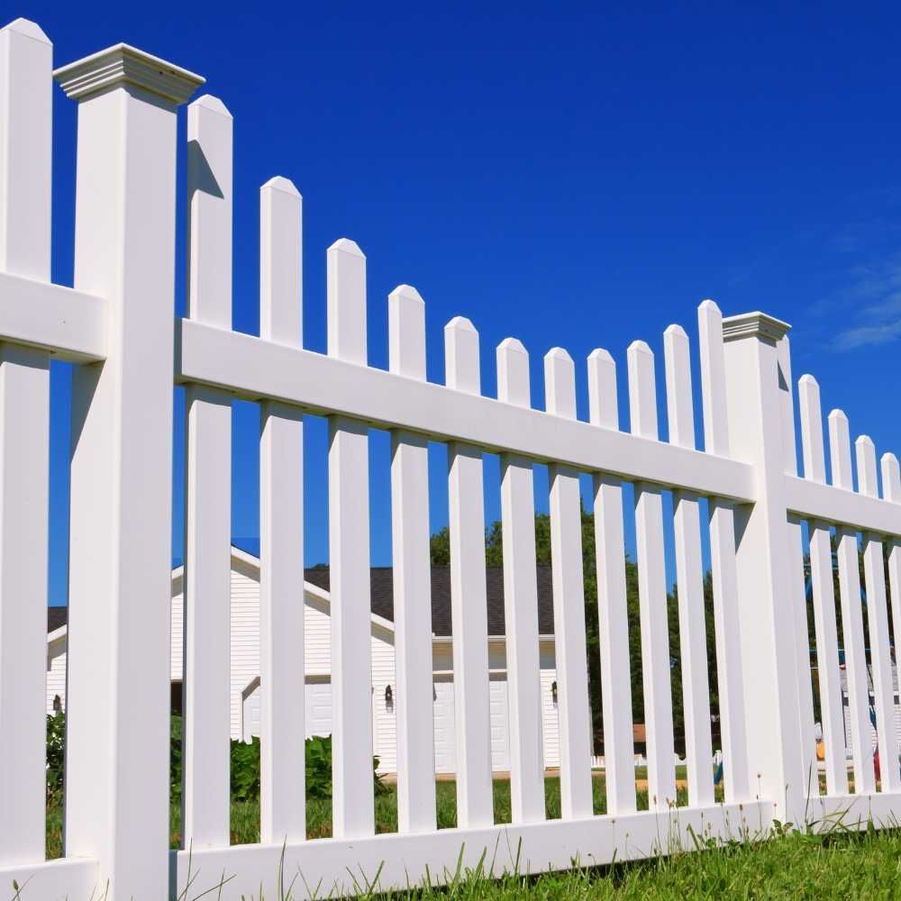 A white picket fence with a blue sky in the background