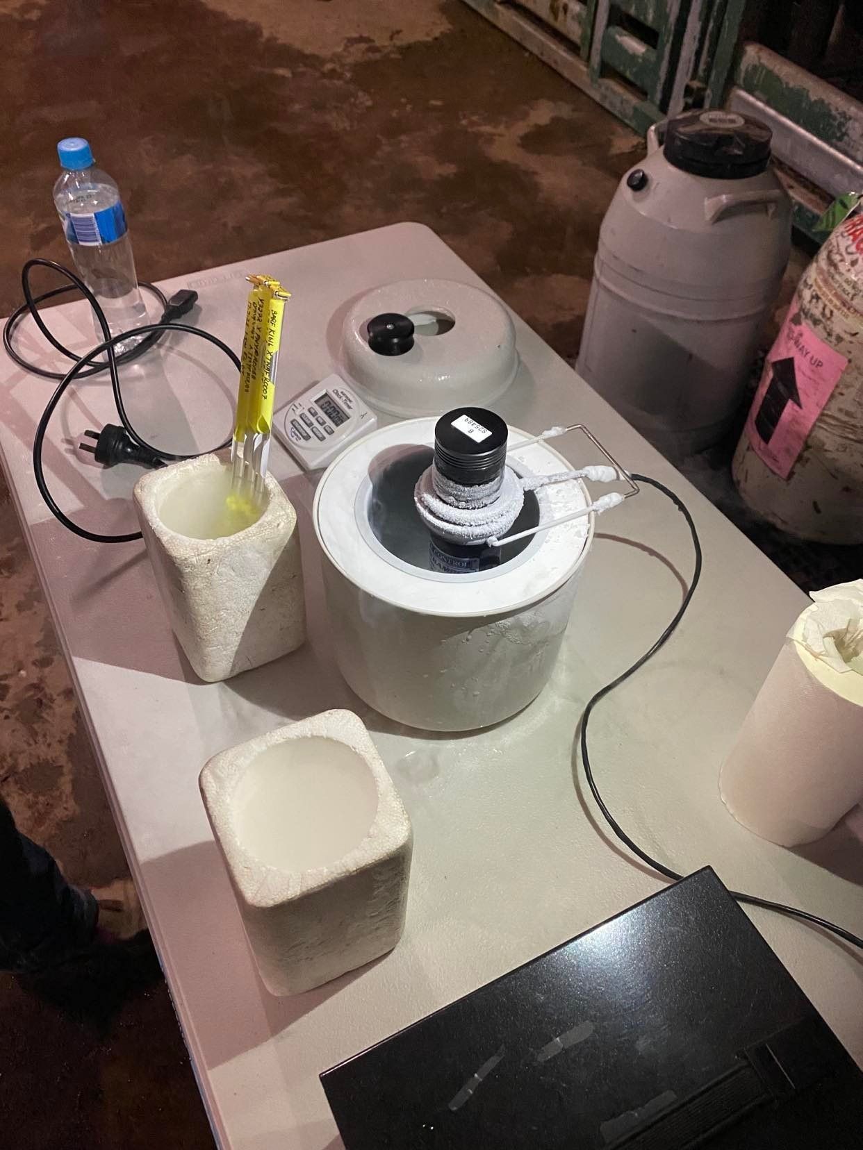 A table with a bunch of objects on it and a bottle of water.