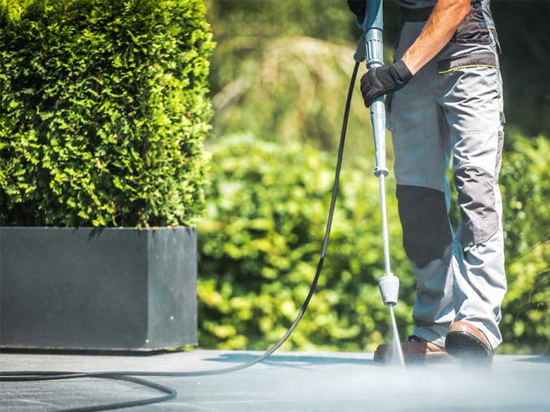 A Man Using High Pressure Cleaning Equipment — Property Maintenance & Garden Care in Beerwah, QLD