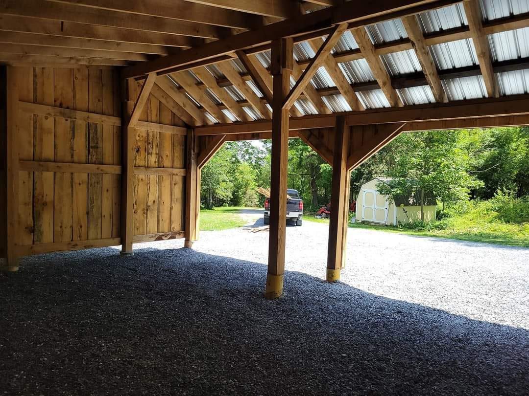 The inside of a wooden barn with a metal roof.