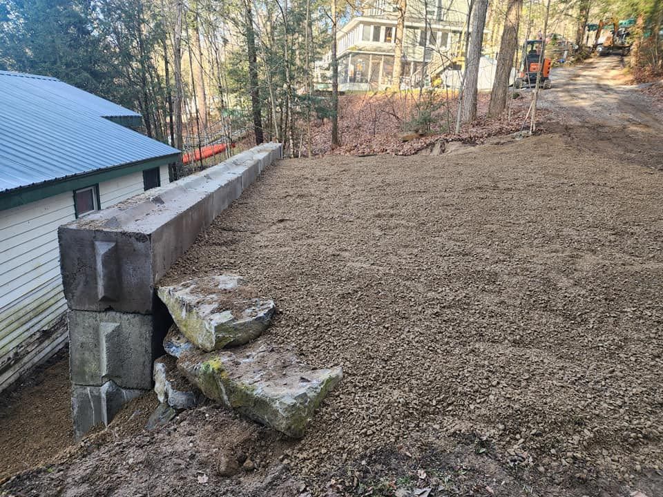 A house is sitting on a hill next to a dirt road.