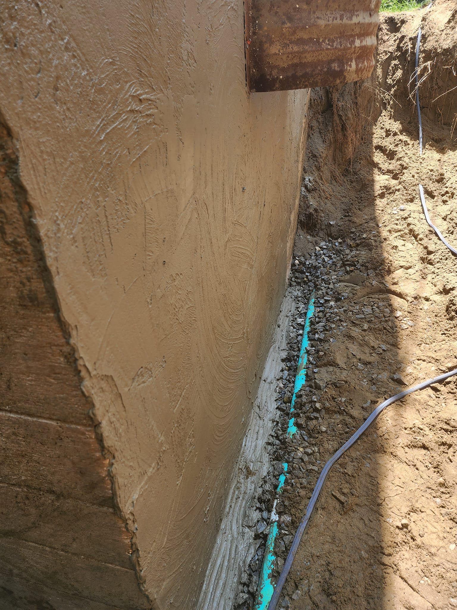 A close up of a concrete wall with a hose attached to it.