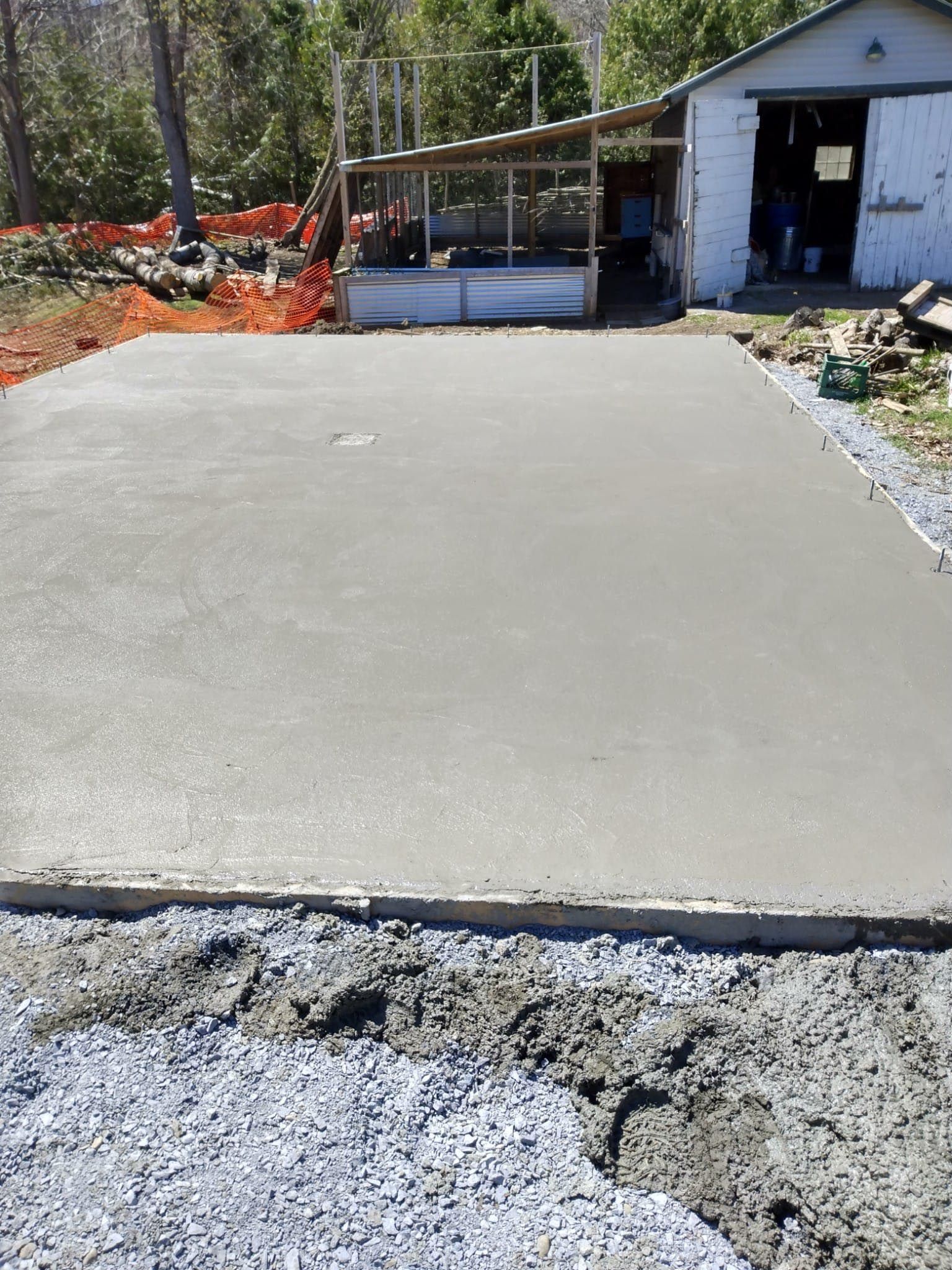 A concrete driveway is being built in front of a garage.
