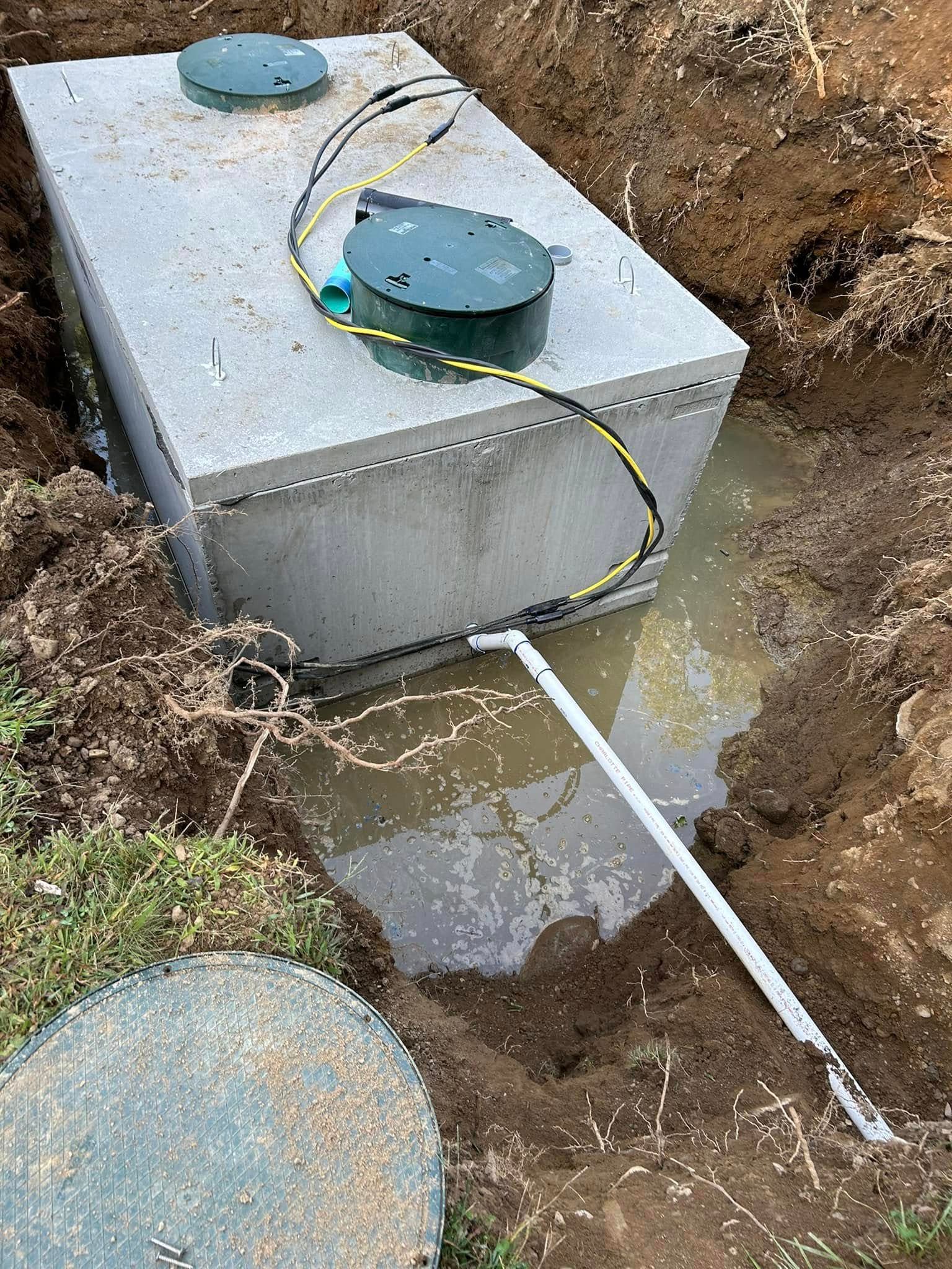 A septic tank is sitting in the middle of a muddy area.