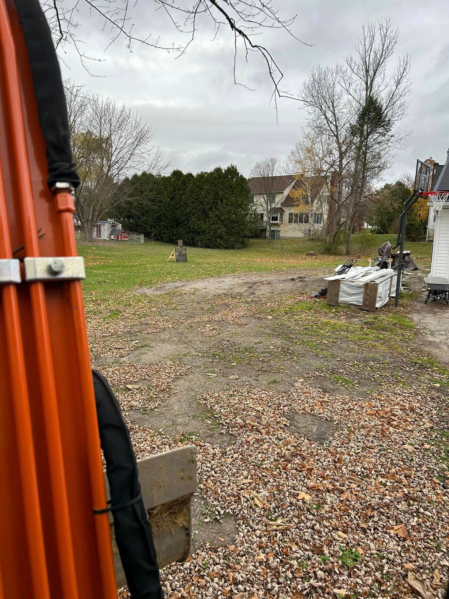 A large orange pole is sitting in the middle of a dirt field.