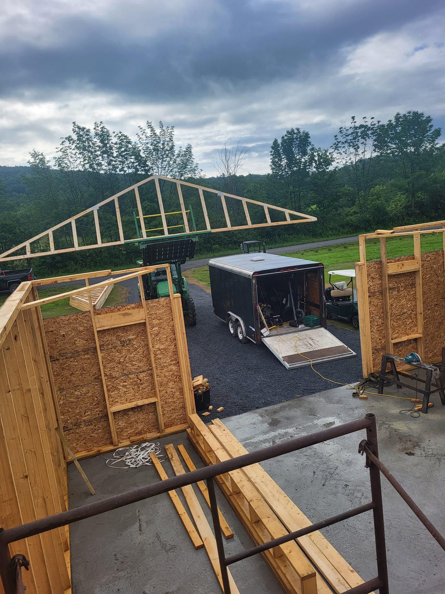 A large wooden structure is being built in a parking lot.