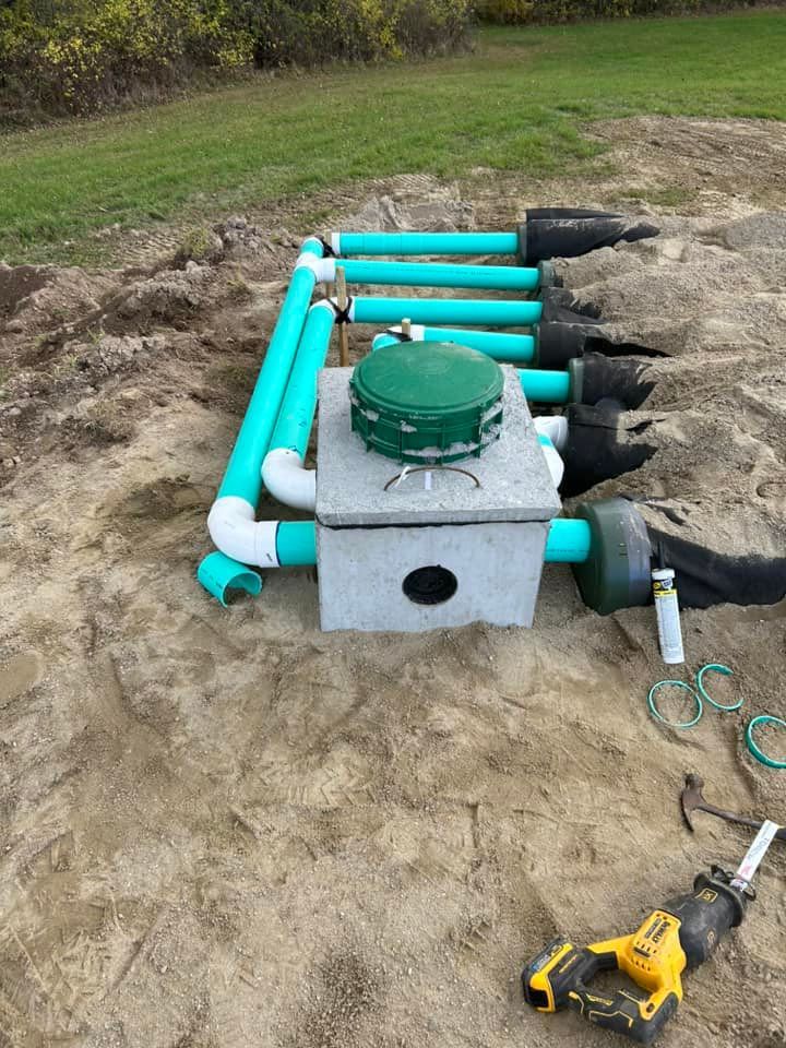 A septic tank is being built in the dirt next to a drill.