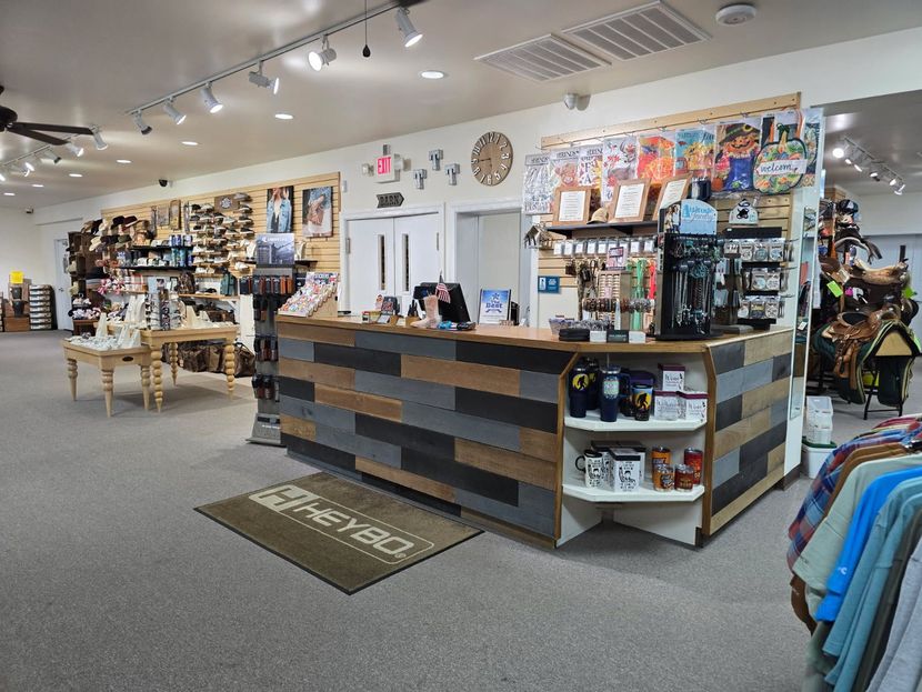 A retail store interior with a wood-paneled counter, products on display, and a Heybo welcome mat.