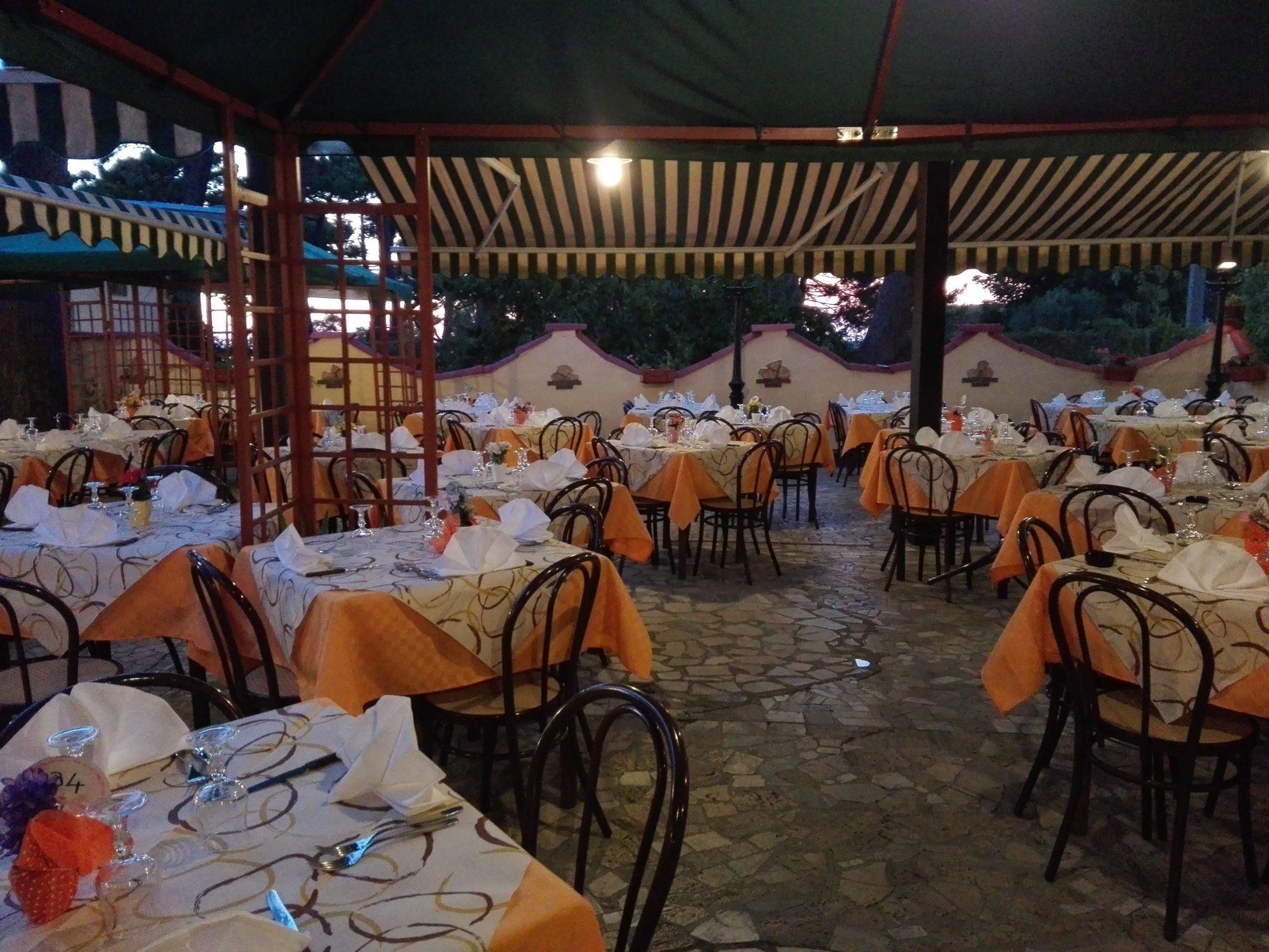 cortile di un ristorante con tavoli sotto la veranda