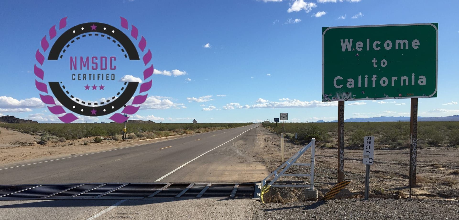 A green welcome to california sign is on the side of a desert road.