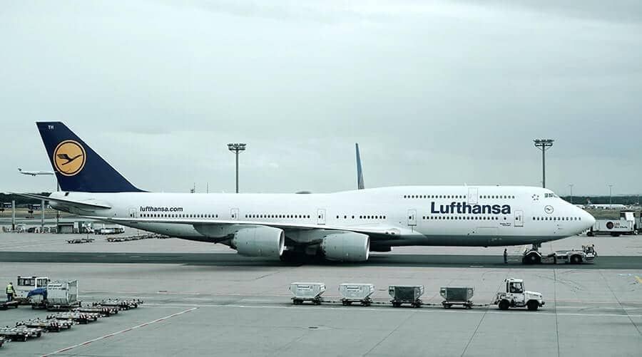 A lufthansa plane is parked on the tarmac at an airport