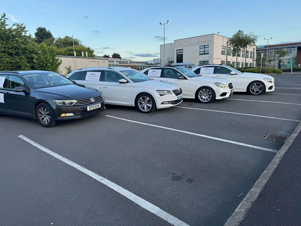 A row of cars are parked in a parking lot.