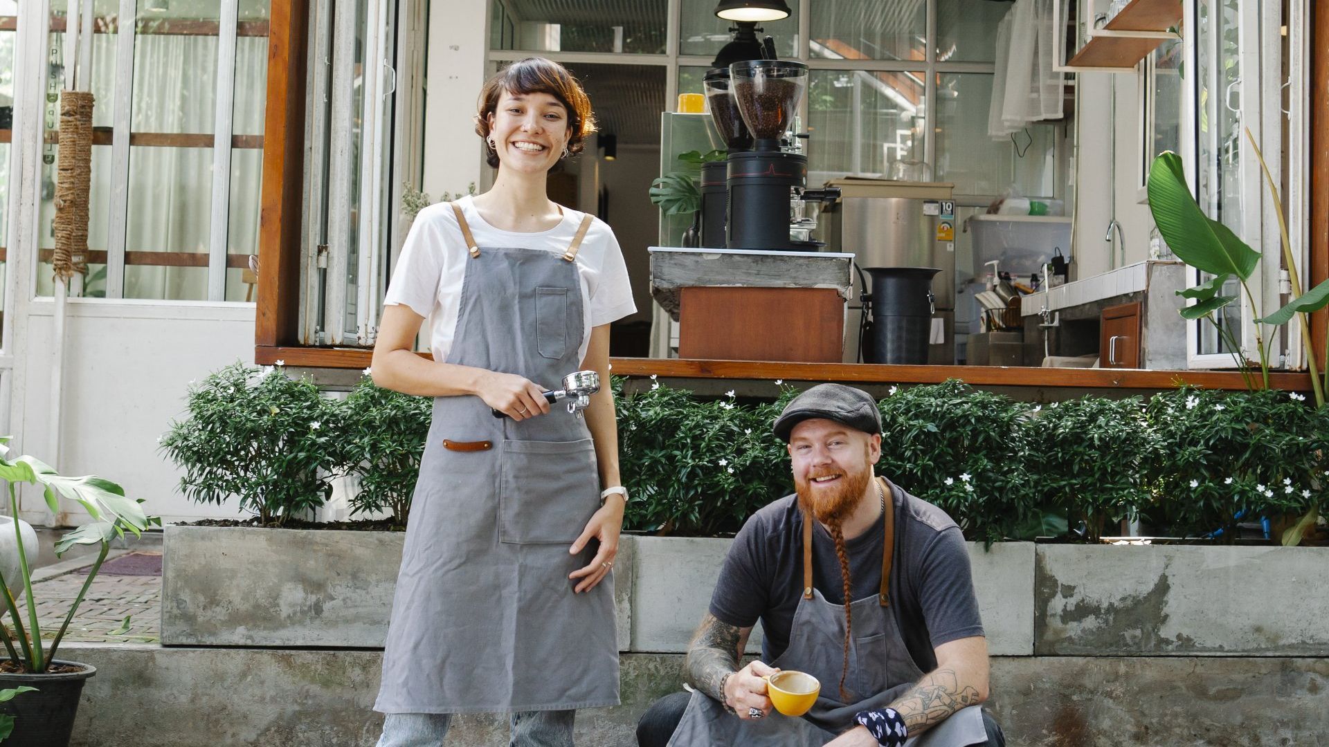 Local Map Listings.  A man and a woman are posing for a picture in front of a coffee shop.