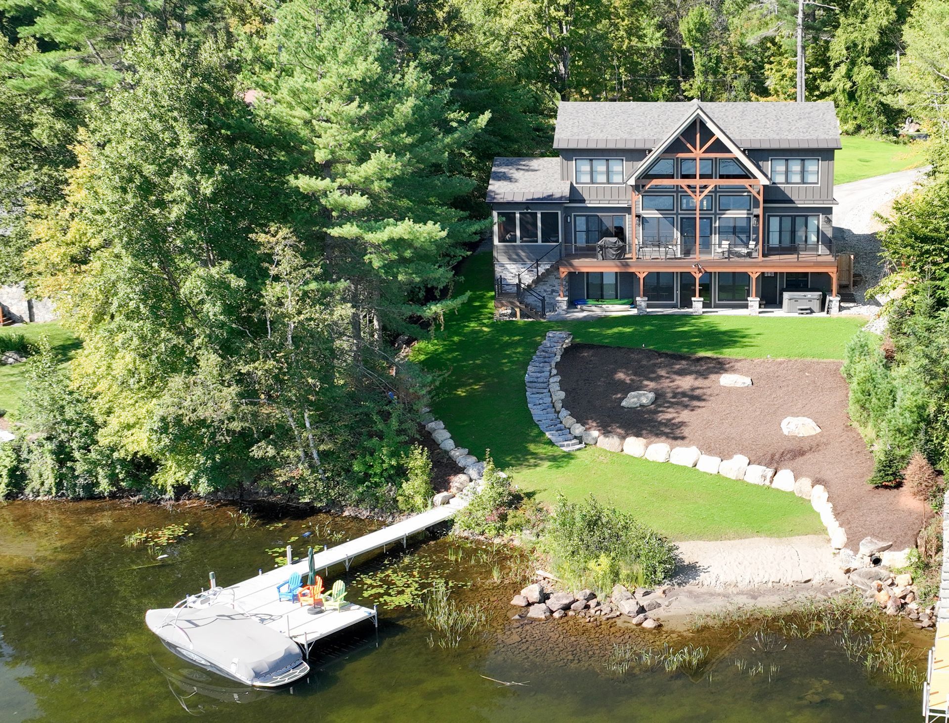 An aerial view of a large house on a lake