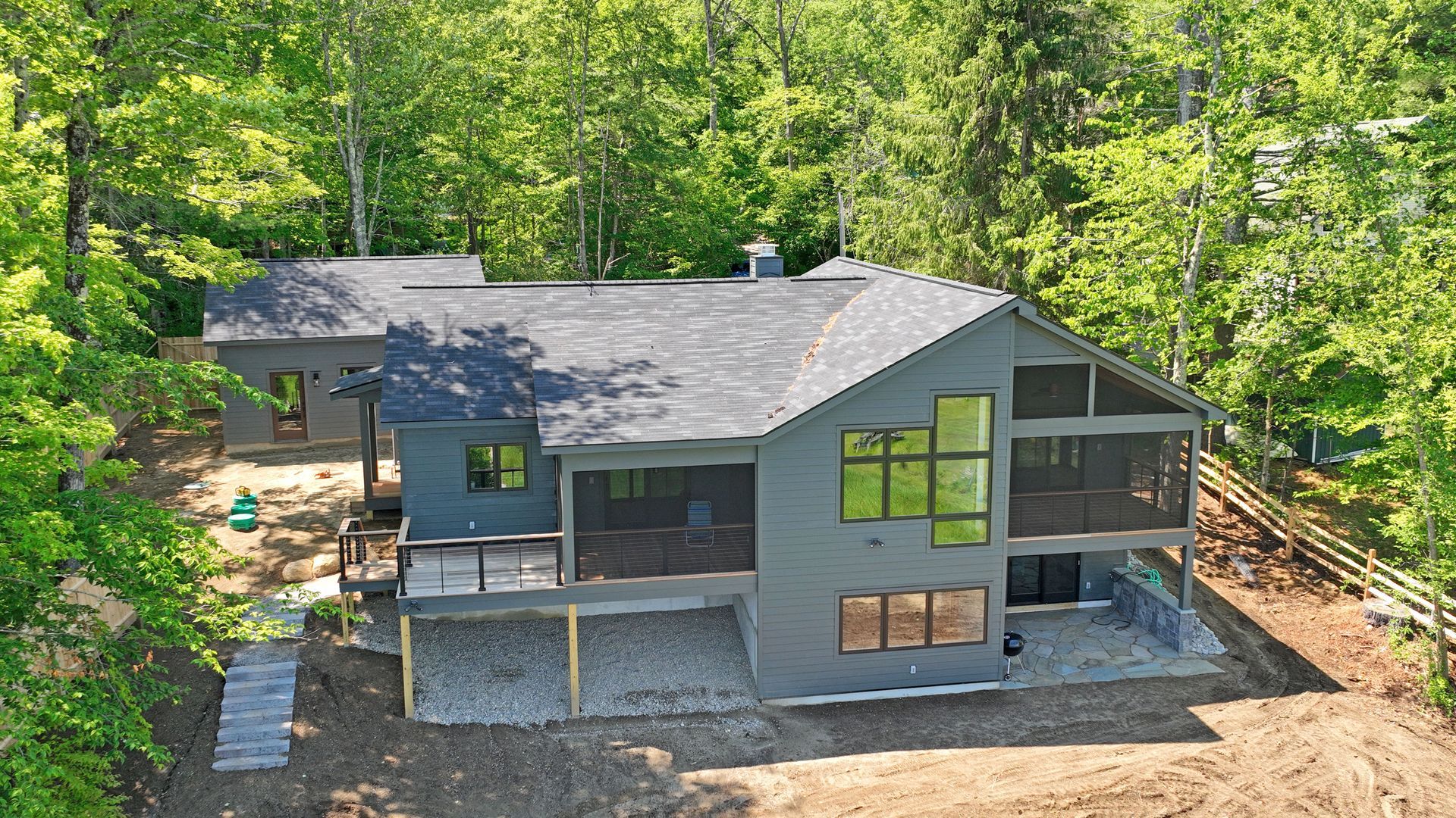 An aerial view of a house in the middle of a forest.