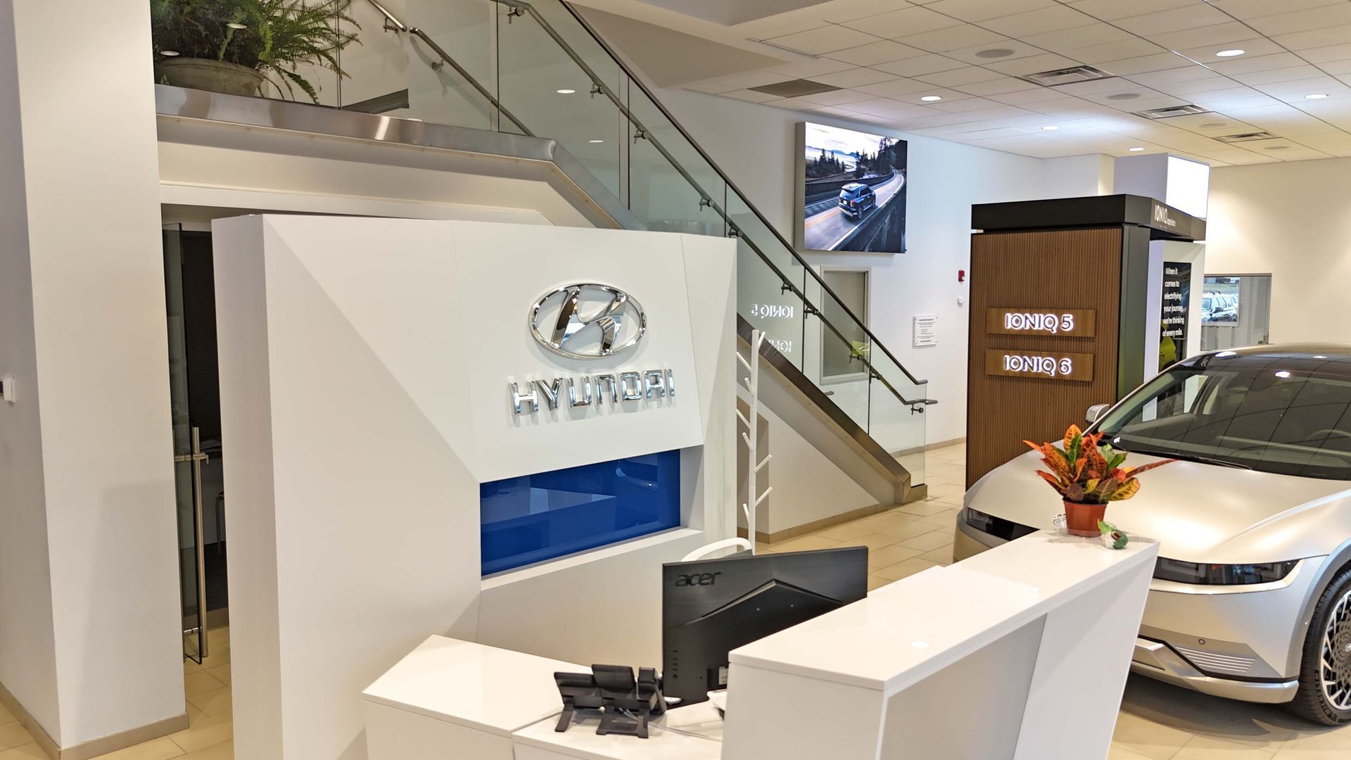 A hyundai car is parked in the lobby of a car dealership.