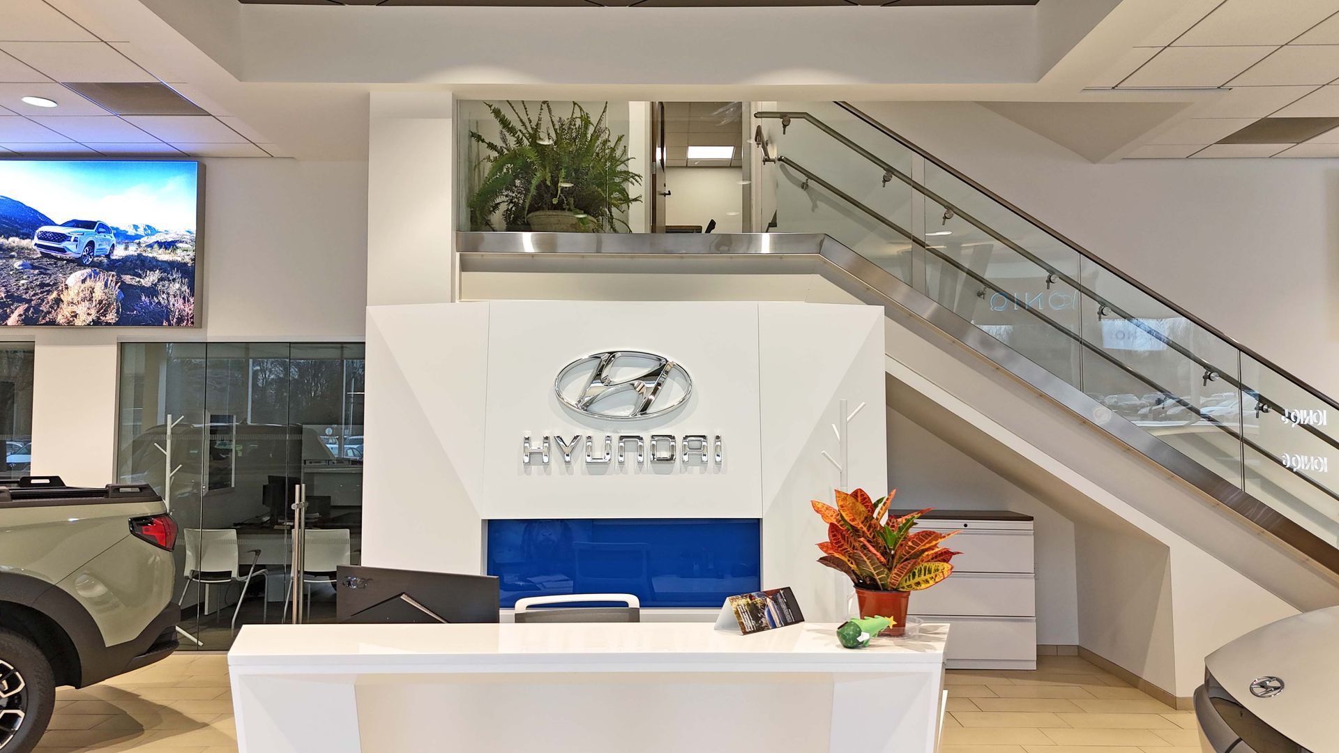 A hyundai dealership with a reception desk and stairs.