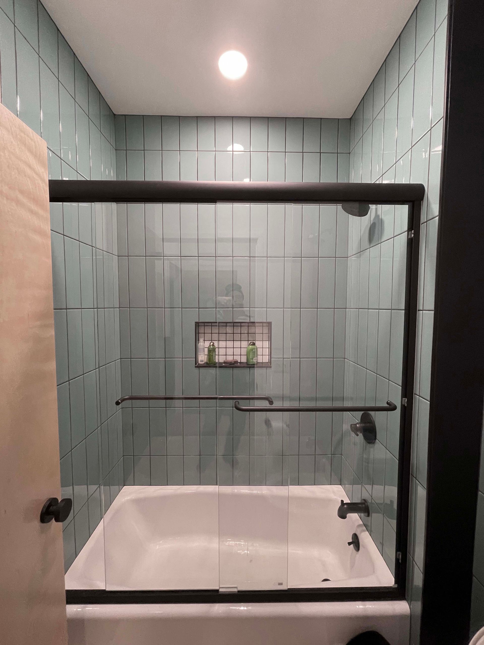 A bathroom with a tub and a shower with a glass door.