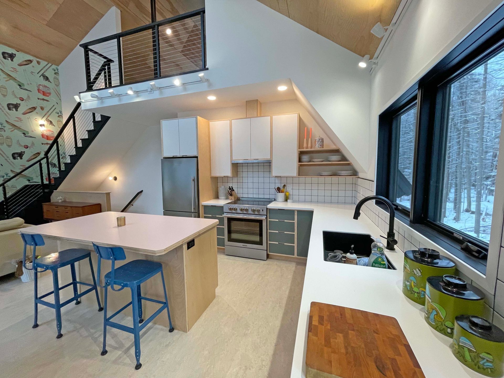 A kitchen with a large island and a staircase leading to the second floor.