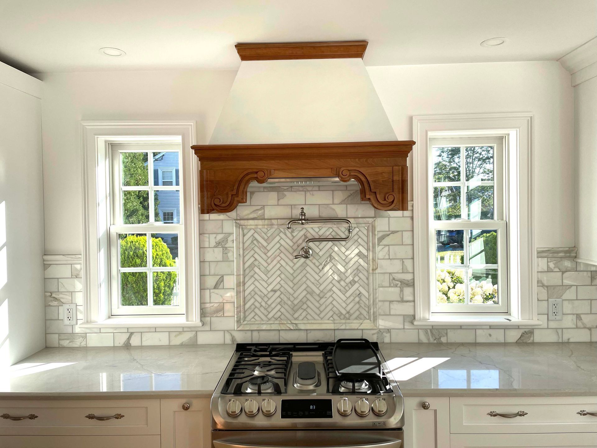 A kitchen with a stove top oven and a wooden hood.
