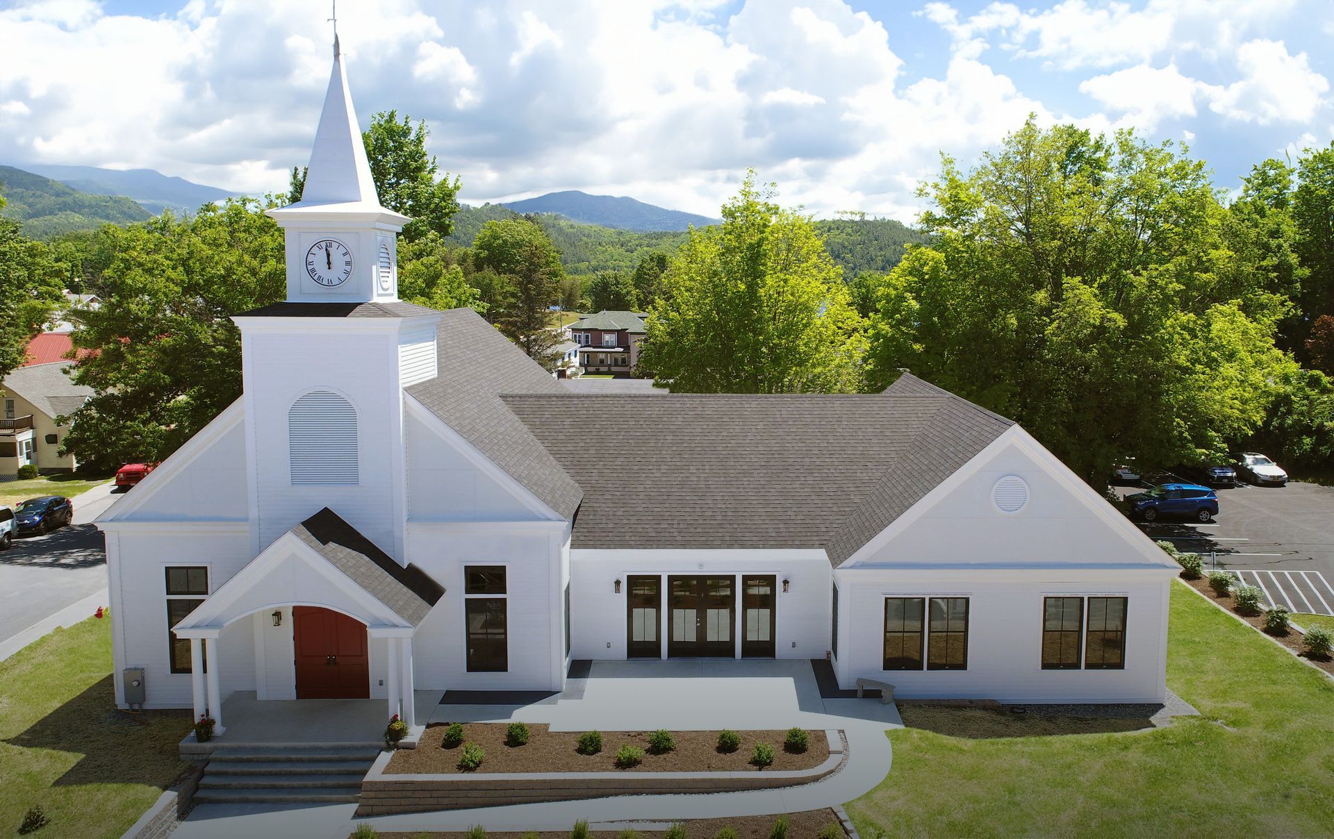 An aerial view of a white church with a clock tower