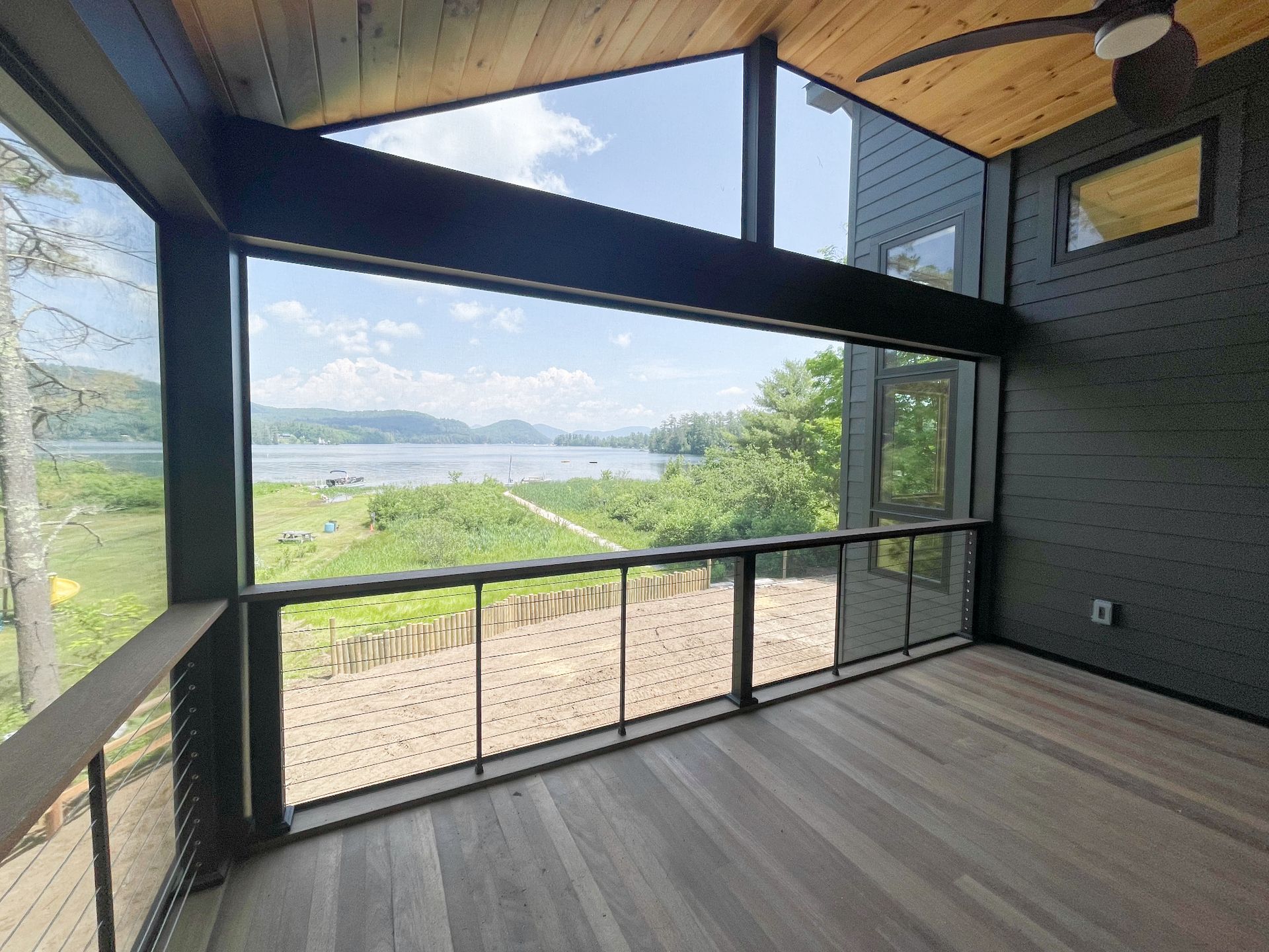 A screened in porch with a view of a lake.
