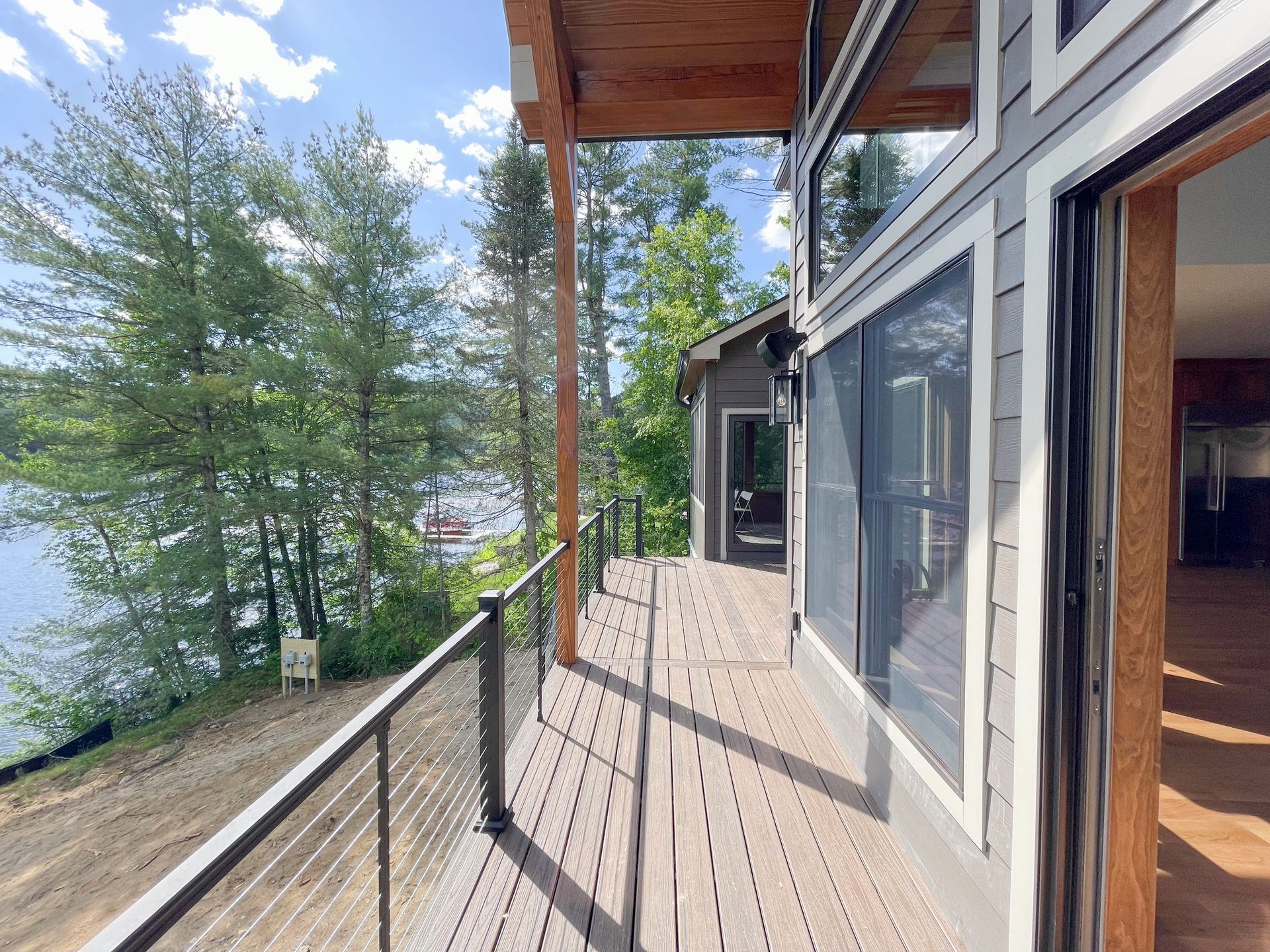 A large deck with a view of a lake and trees.