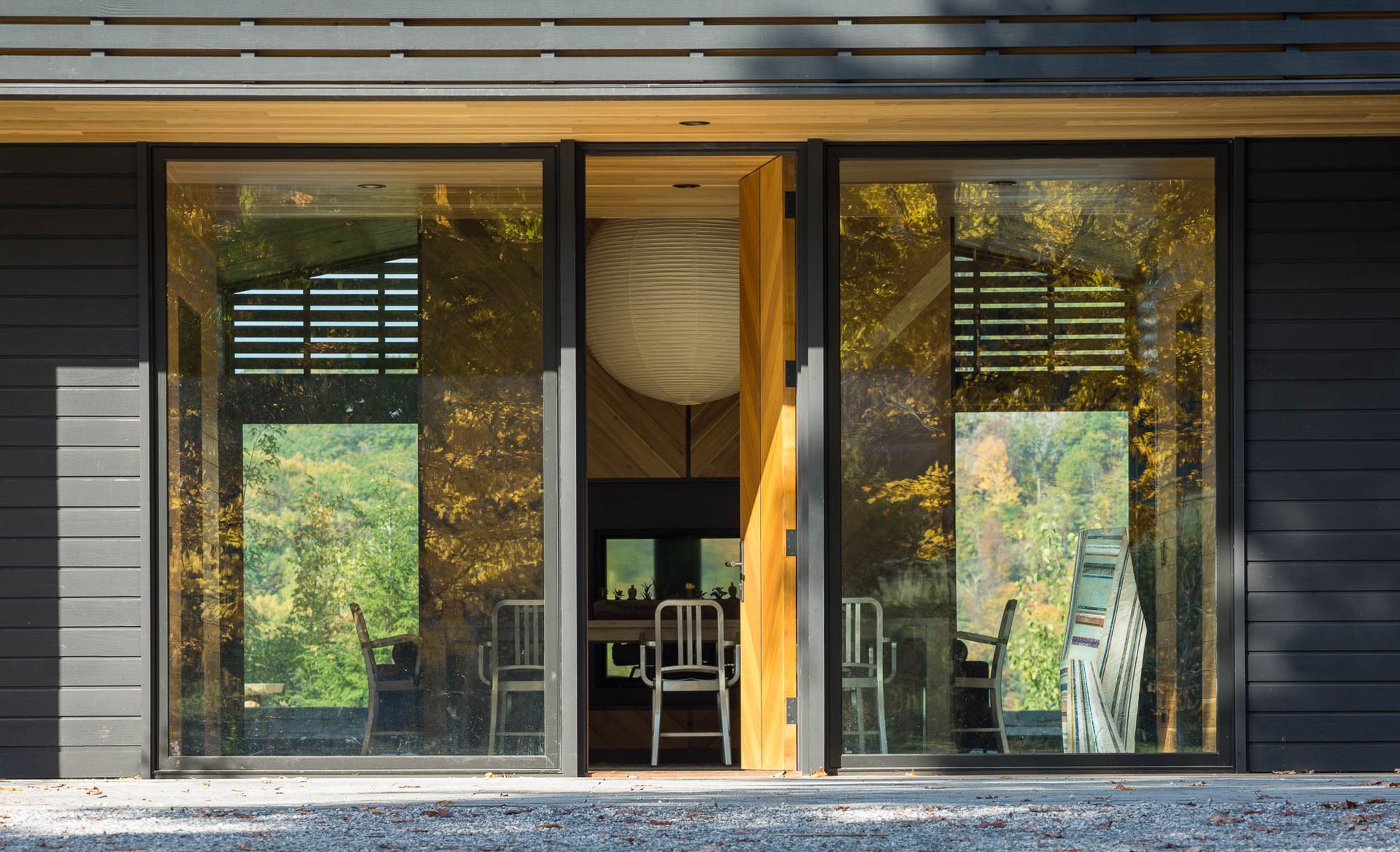 A house with a lot of windows and a door that is open.