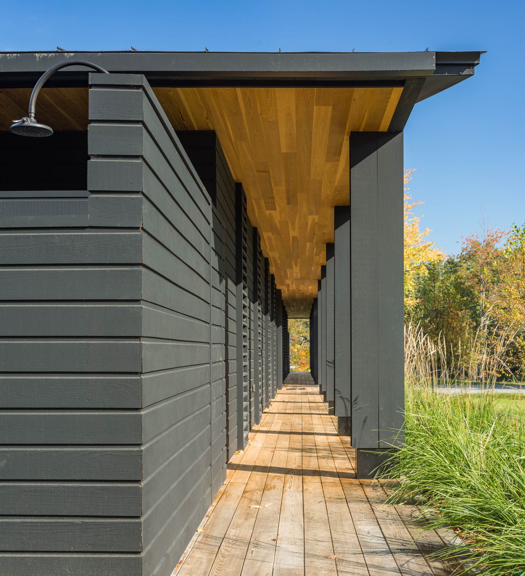 A long walkway leading to a house with a shower on the roof