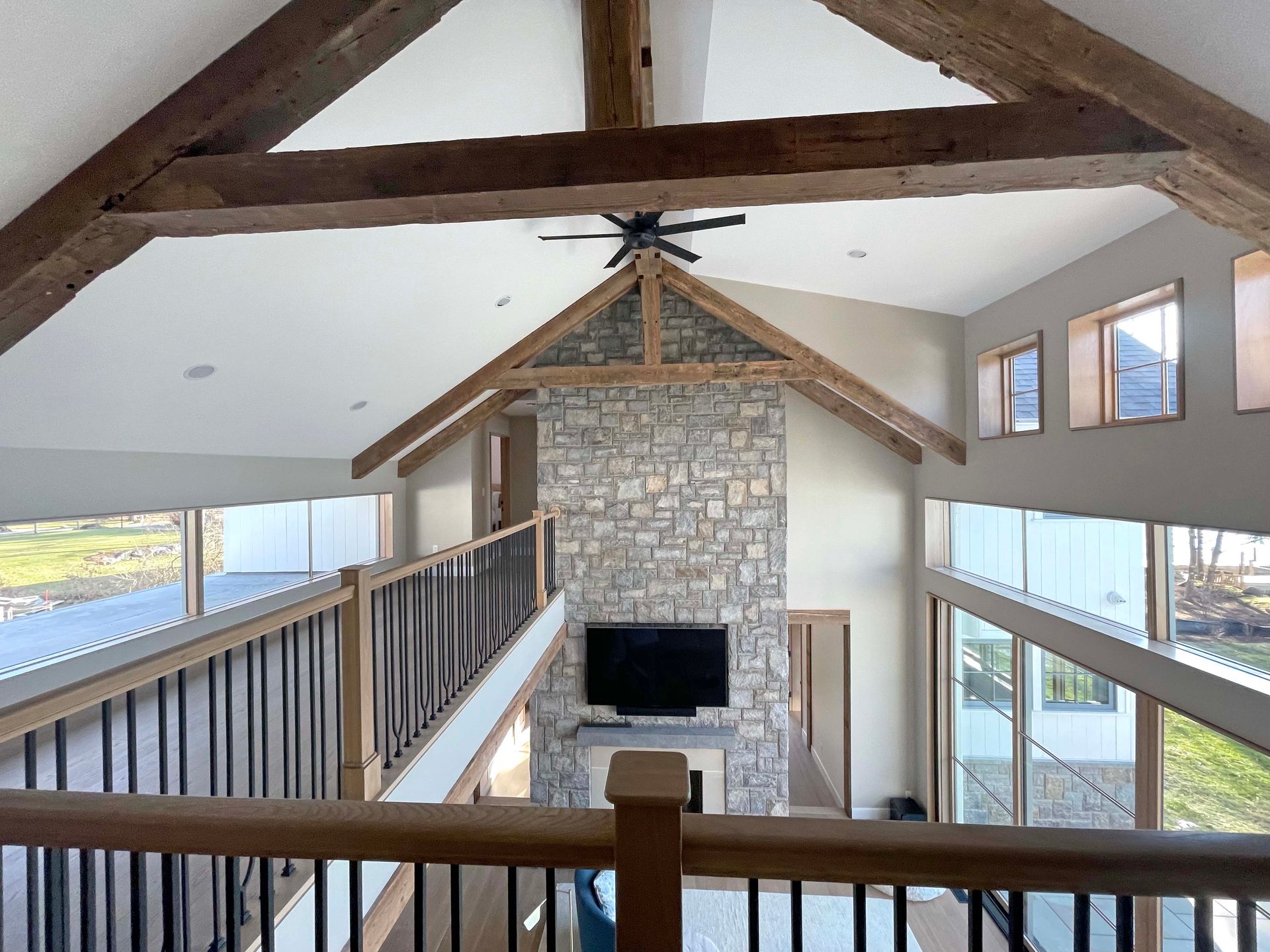 A living room with a stone fireplace and a flat screen tv